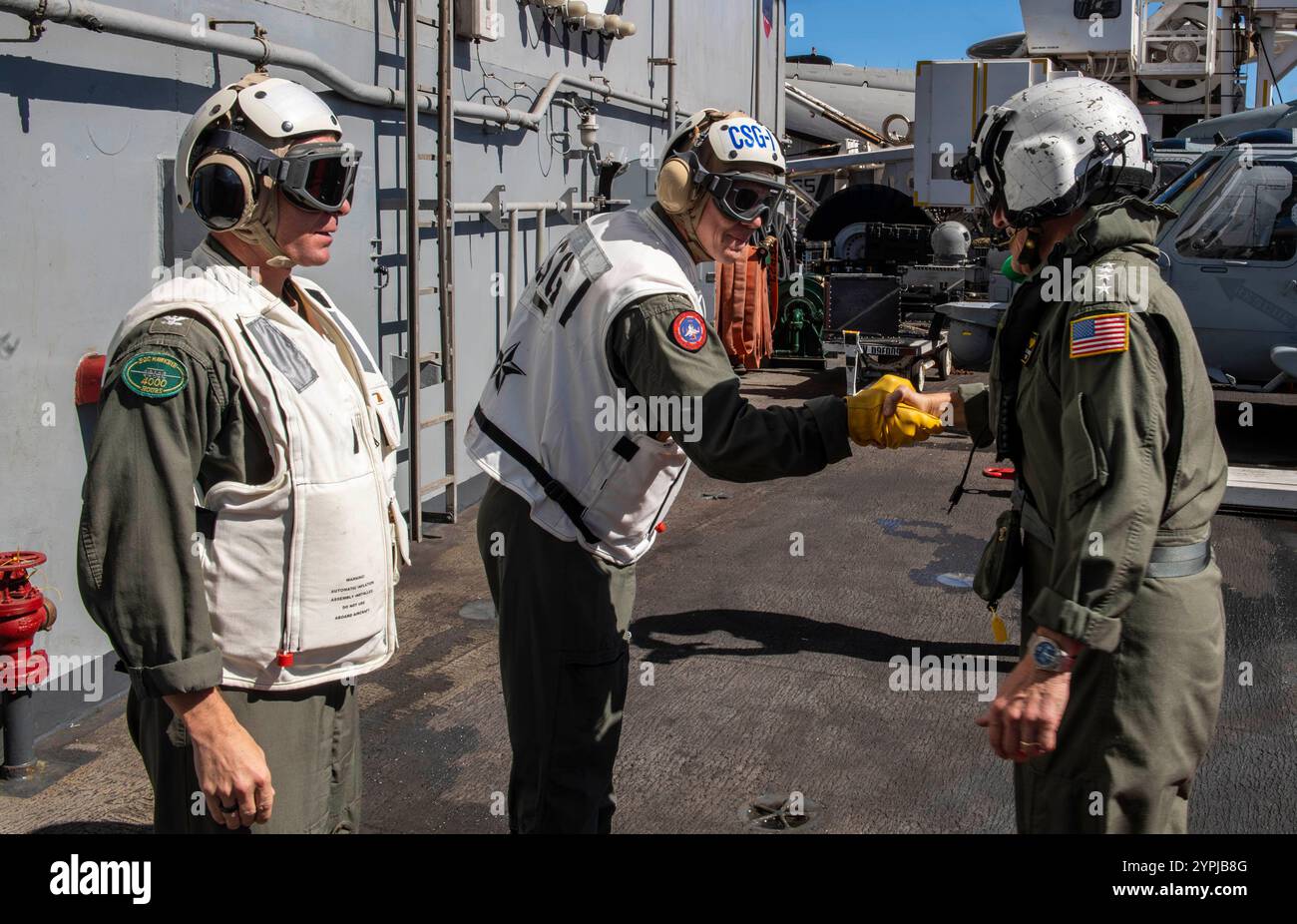PACIFIC OCEAN (27. November 2024) ADM. Steve Koehler, rechts, Kommandeur der US-Pazifik-Flotte, begrüsst die hintere ADM. Michael Wosje, Kommandeur der Carrier Strike Group ONE, Center, und Kapitän Matthew Thomas, Kommandeur des Flugzeugträgers USS Carl Vinson (CVN 70) bei seiner Ankunft für einen Schiffsbesuch an Bord von Vinson am 27. November 2024. Carl Vinson, das Flaggschiff der Carrier Strike Group ONE, führt derzeit Routineoperationen im Einsatzgebiet der 3rd Fleet durch. (Foto der U.S. Navy von Mass Communication Specialist 3rd Class Nate Jordan) Stockfoto