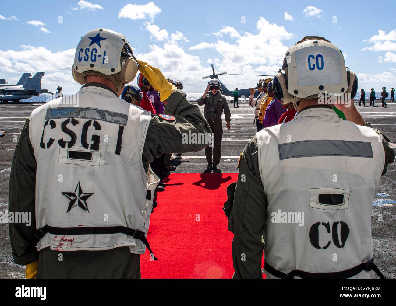 PACIFIC OCEAN (27. November 2024) ADM. Steve Koehler, Center, Kommandant der U.S. Pacific Fleet, gibt einen Gruß zurück. als Sideboys erweisen sich bei seiner Ankunft Auszeichnungen für einen Schiffsbesuch an Bord des Flugzeugträgers USS Carl Vinson (CVN 70) der Nimitz-Klasse am 27. November 2024. Carl Vinson, das Flaggschiff der Carrier Strike Group ONE, führt derzeit Routineoperationen im Einsatzgebiet der 3rd Fleet durch. (Foto der U.S. Navy von Mass Communication Specialist 3rd Nate Jordan) Stockfoto