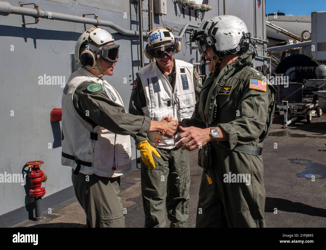 PACIFIC OCEAN (27. November 2024) ADM. Steve Koehler, rechts, Kommandant der U.S. Pacific Fleet, begrüßt Kapitän Matthew Thomas, links, Kommandeur des Flugzeugträgers USS Carl Vinson (CVN 70) der Nimitz-Klasse und Michael Wosje, Kommandeur der Carrier Strike Group ONE, bei seiner Ankunft für einen Schiffsbesuch an Bord von Vinson am 27. November 2024. Carl Vinson, das Flaggschiff der Carrier Strike Group ONE, führt derzeit Routineoperationen im Einsatzgebiet der 3rd Fleet durch. (Foto der U.S. Navy von Mass Communication Specialist 3rd Class Nate Jordan) Stockfoto