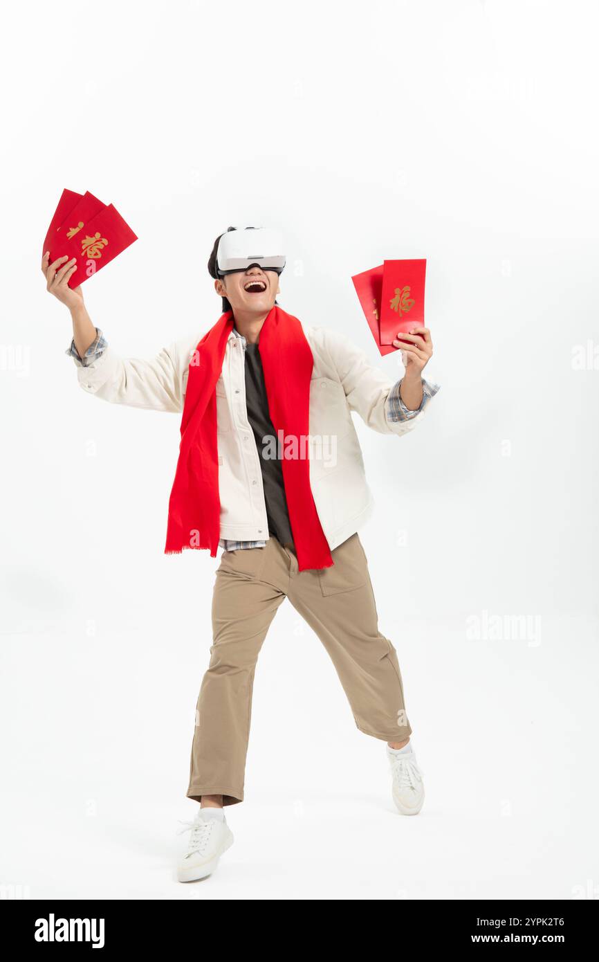 Ein junger asiatischer Mann, der VR trägt und einen roten Umschlag hält Stockfoto