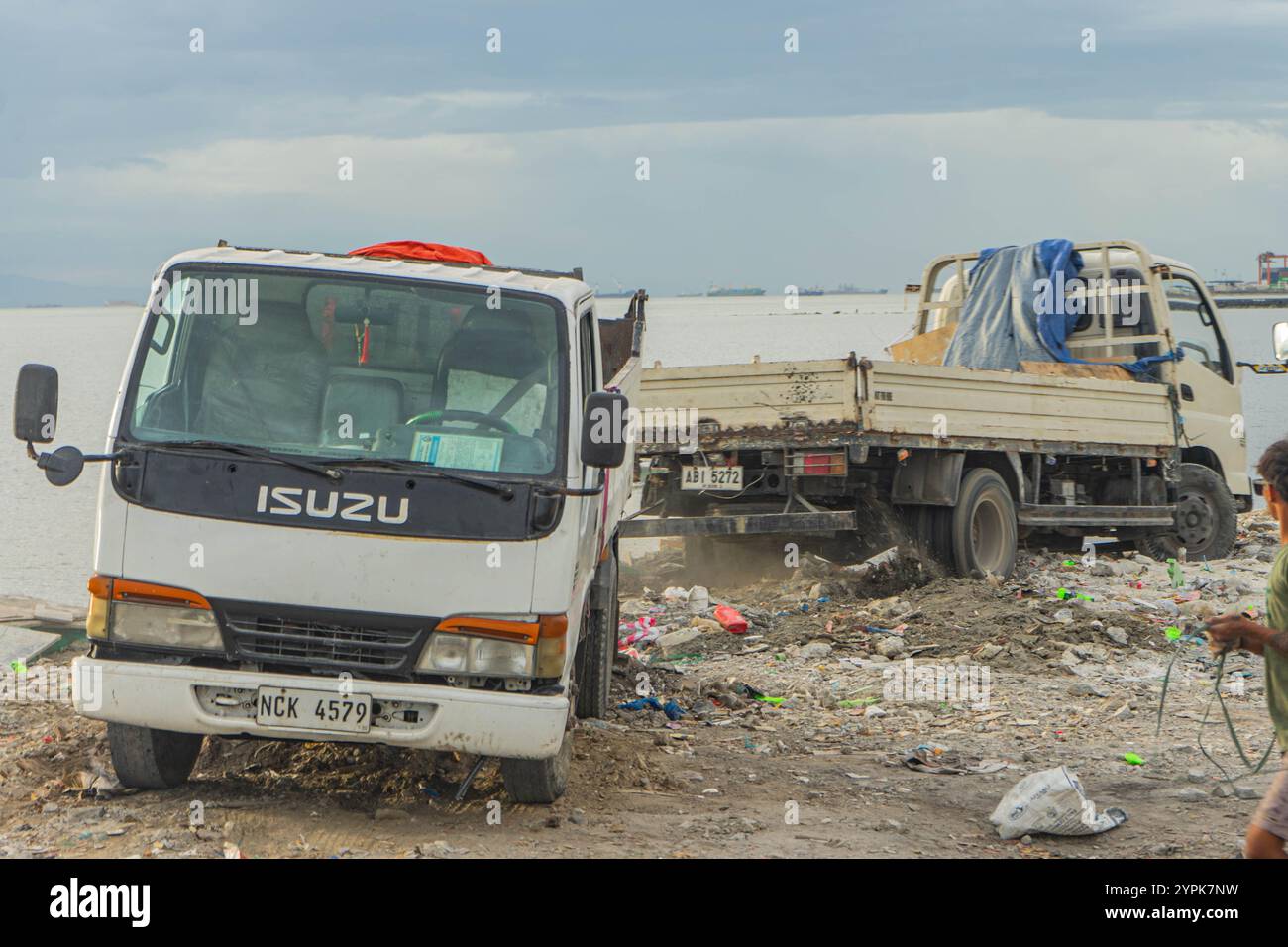 Quezon City, Quezon, Philippinen. November 2024. Ein LKW versucht, einen anderen LKW zu ziehen, der im Müllhaufen stecken geblieben ist. (Kreditbild: © Kenosis Yap/ZUMA Press Wire) NUR REDAKTIONELLE VERWENDUNG! Nicht für kommerzielle ZWECKE! Stockfoto