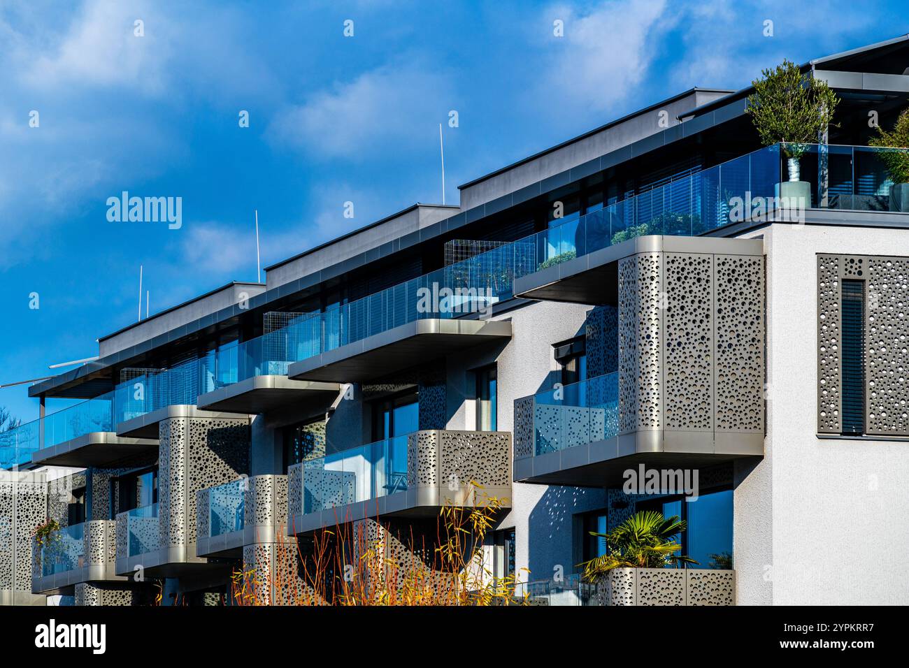 Luxuriöse Fassade des Apartmentgebäudes mit komplexen Goldtäfelungen und Glasbalkonen Stockfoto