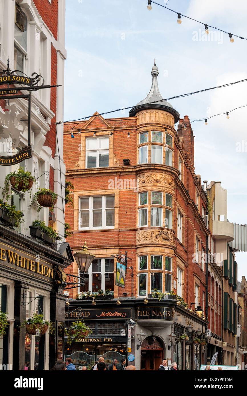 Historische White Lion und Nags Head Pubs in viktorianischem rotem Backsteingebäude mit verziertem Turm und Erkerfenstern, Covent Garden, London Stockfoto