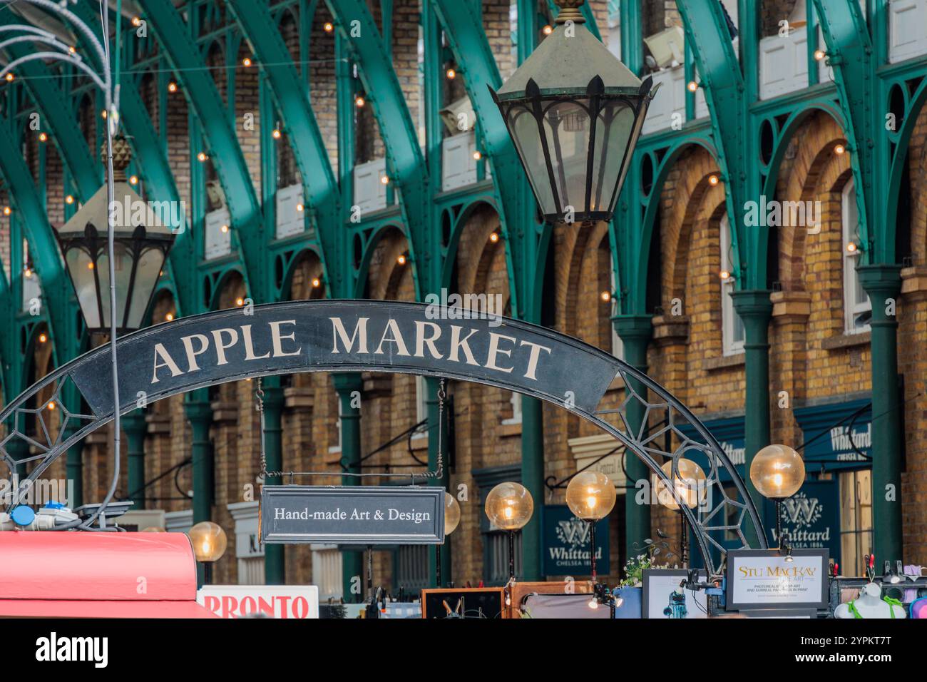 Eintrittsschild für den Apple Market mit beleuchteten Glaskugeln und verzierten grünen Eisenarbeiten im Covent Garden mit handgefertigten Kunst- und Designdisplays Stockfoto