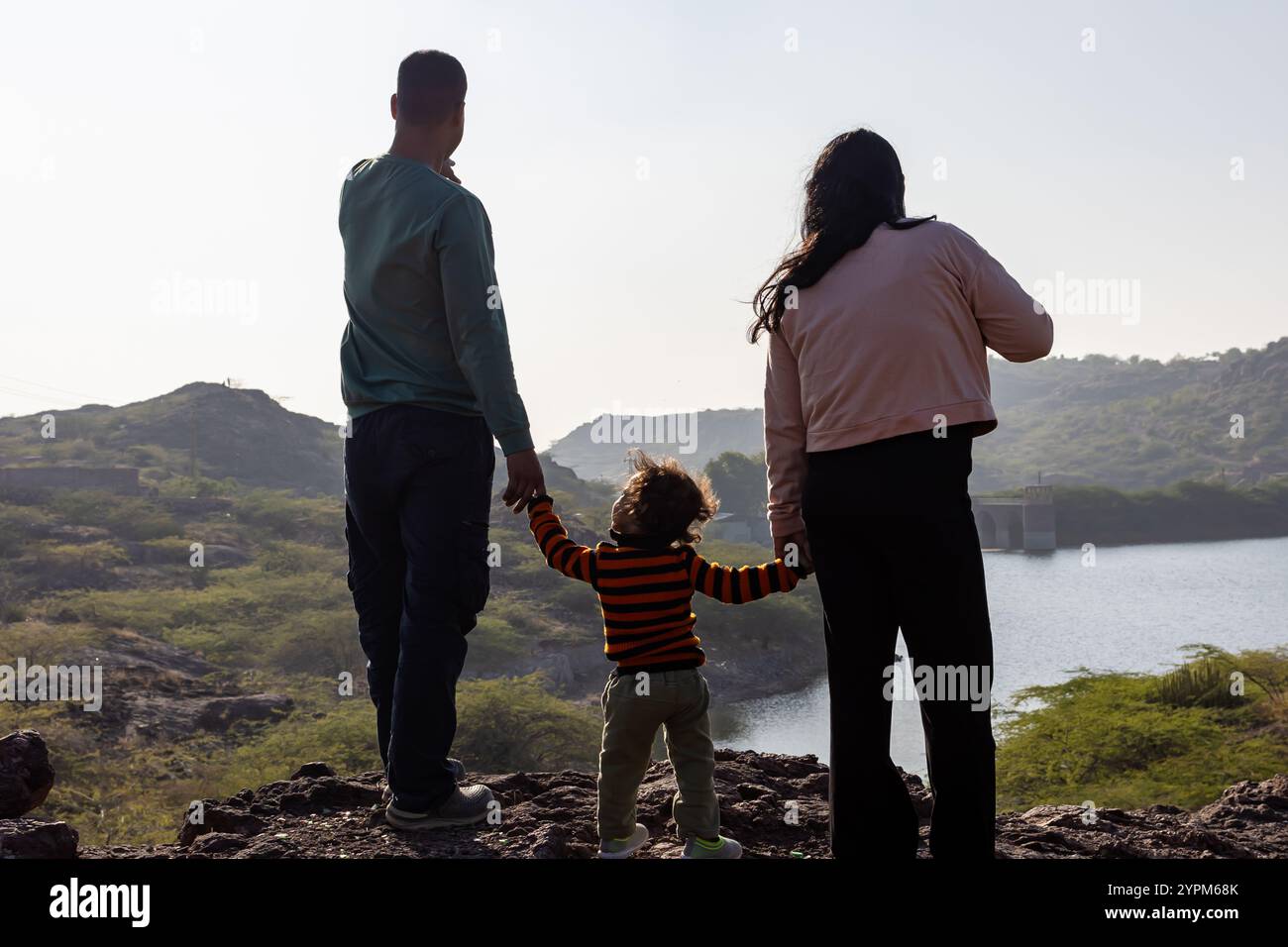 Junge Eltern und Kleinkinder binden am Morgen am Serene Mountain Top Stockfoto