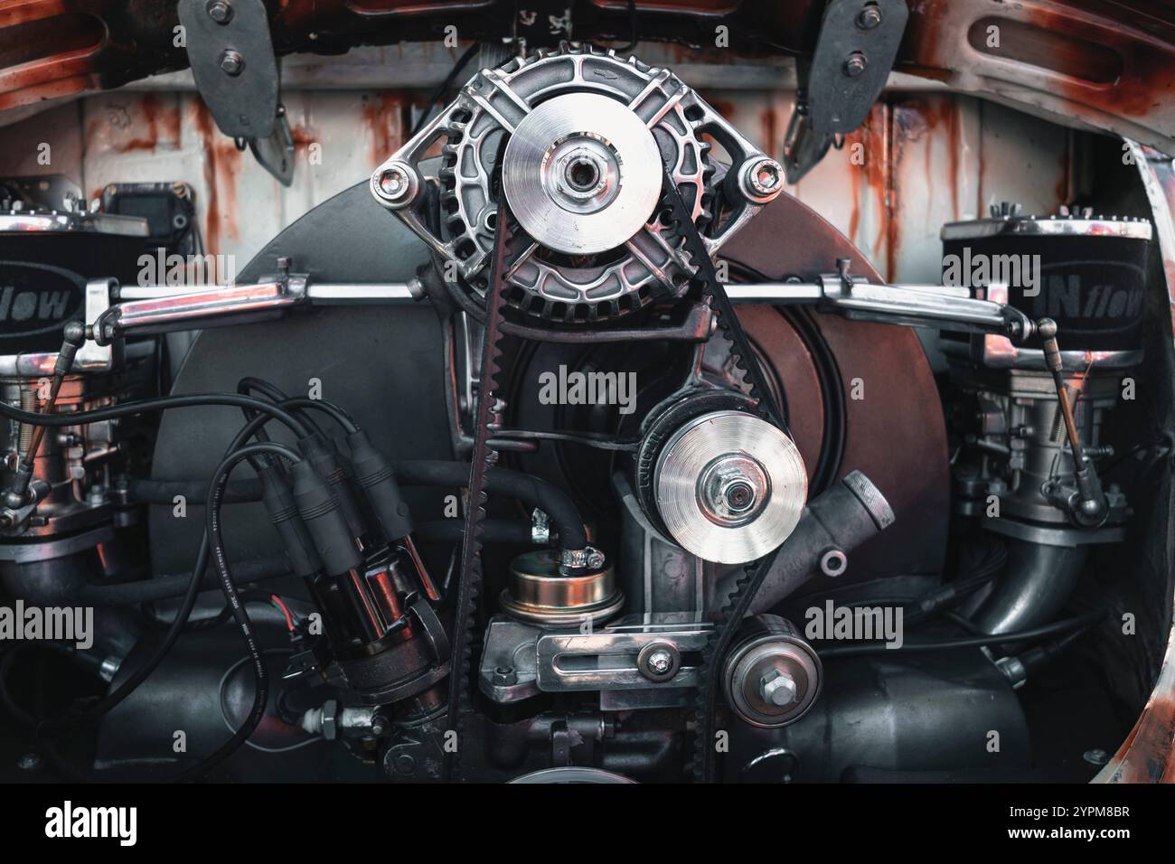 Motor eines alten Autos, mit polierten Metalldetails, Riemen und mechanischen Komponenten gut sichtbar. Stockfoto