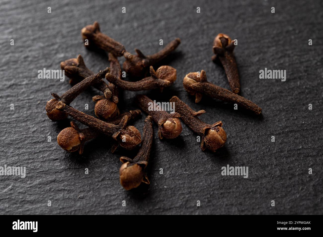 Ganze Nelken würzen auf schwarzem Hintergrund. Haufen trockener Nelkenknospen aus der Nähe. Syzygium aromaticum Dry Buds als Zutat für Kochmakro. Gewürzkonzept Stockfoto