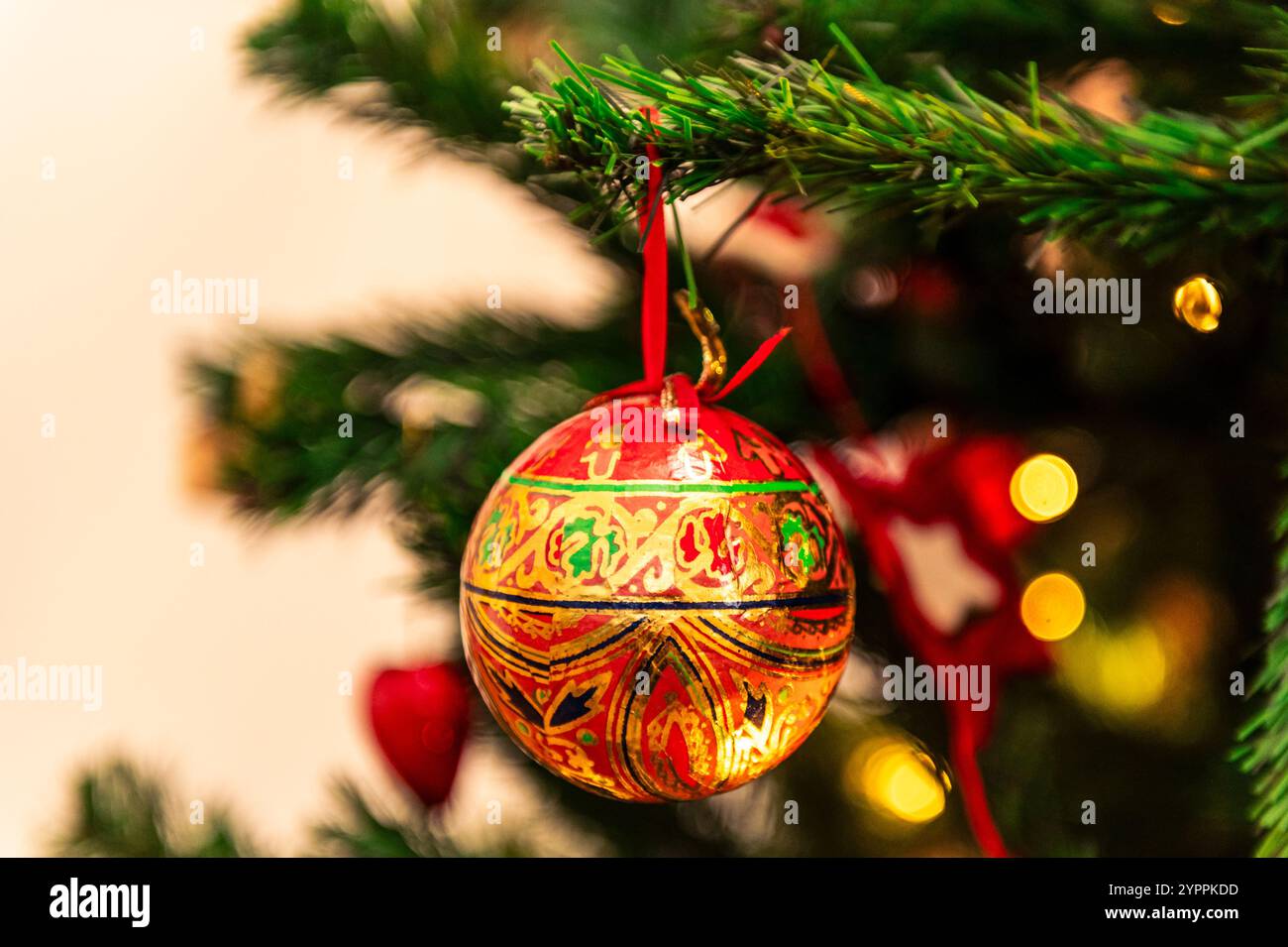 Nahaufnahme einer rot-goldenen kugelförmigen Dekoration auf einem Weihnachtsbaum Stockfoto