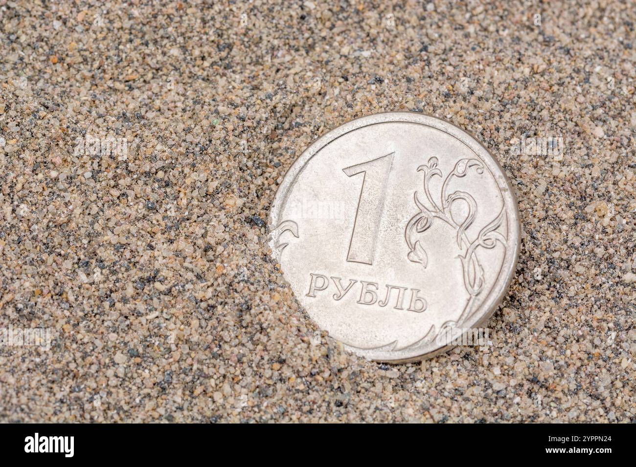 Nahaufnahme einer Rubel-Münze auf Sand. Für den Zusammenbruch von Ruble trifft Ruble den Tiefpunkt, was die russische Kriegswirtschaft, die russischen Schulden und die persönlichen Finanzen zum Scheitern bringt Stockfoto