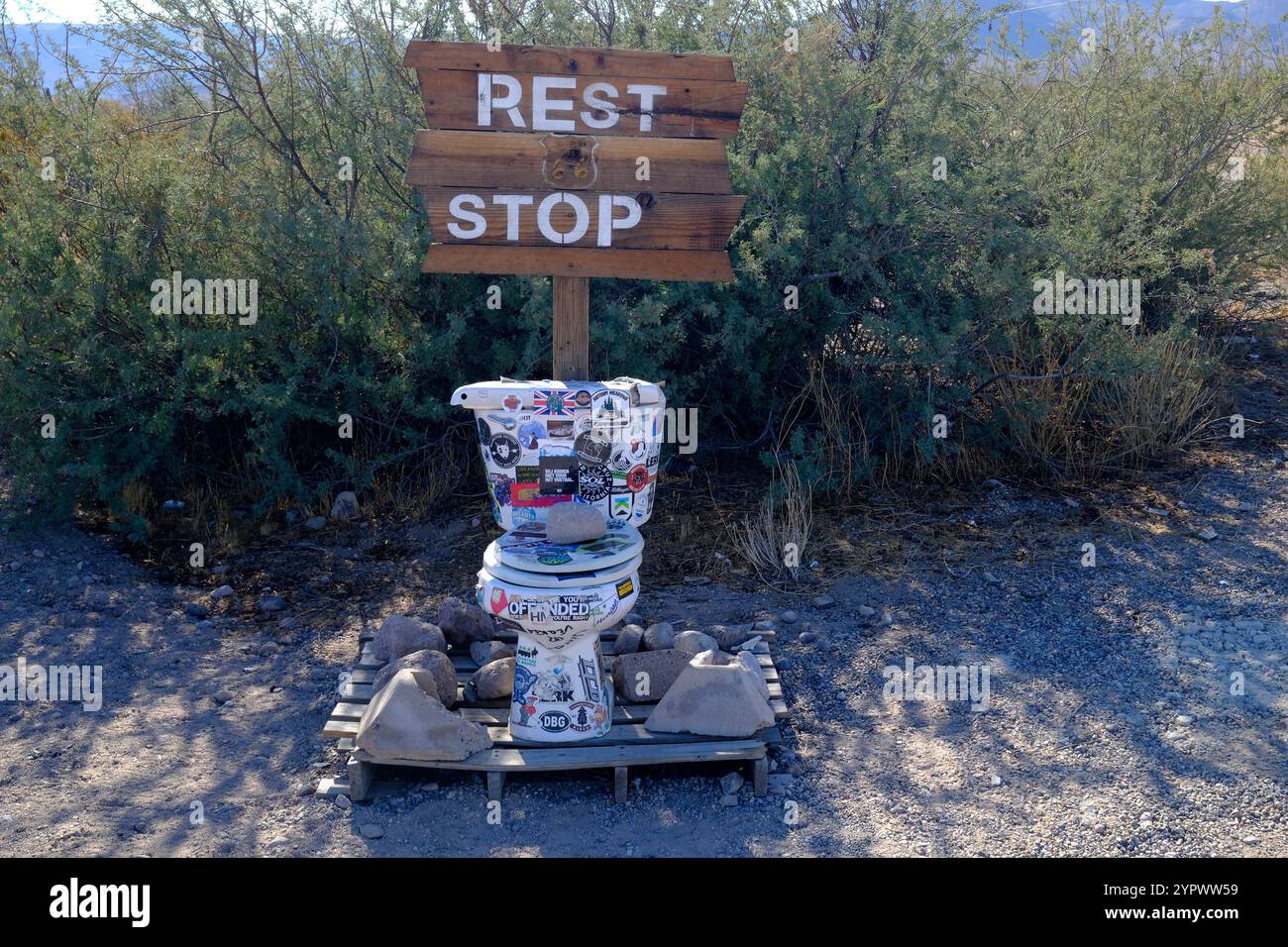 Eine Toilettenschüssel mit einem "Rest Stop"-Schild drauf. Diese humorvolle Ausstellung befindet sich auf der Route 66 in der Wüste außerhalb von Oatman, Arizona Stockfoto