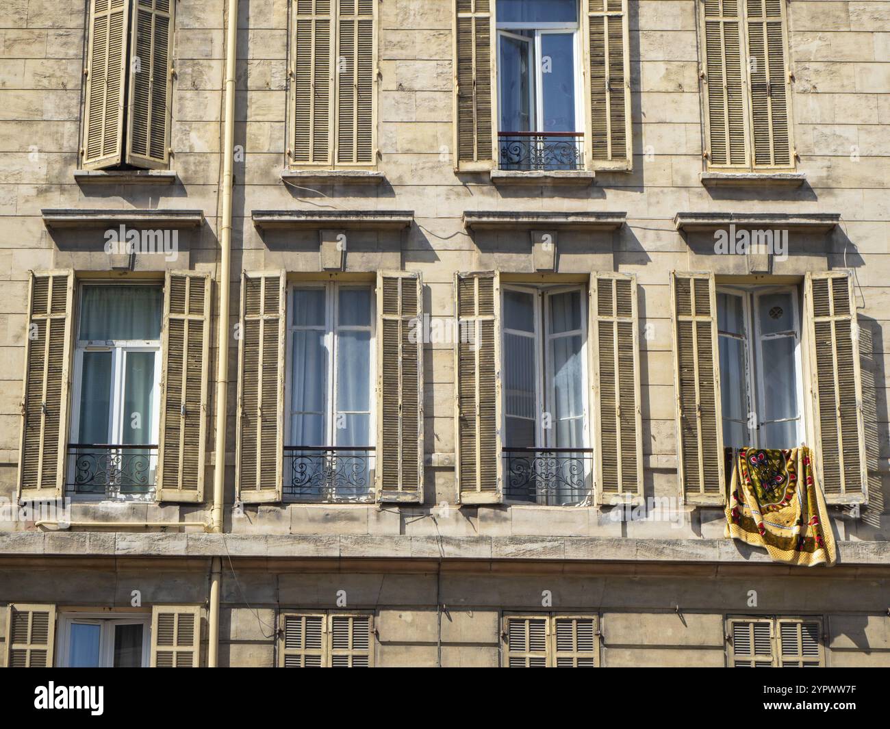 Typische Fassade eines historischen Wohnblocks, der früher als Fabrikgebäude in Marseille genutzt wurde. Der Block zeichnet sich durch hohe Fenster aus Stockfoto