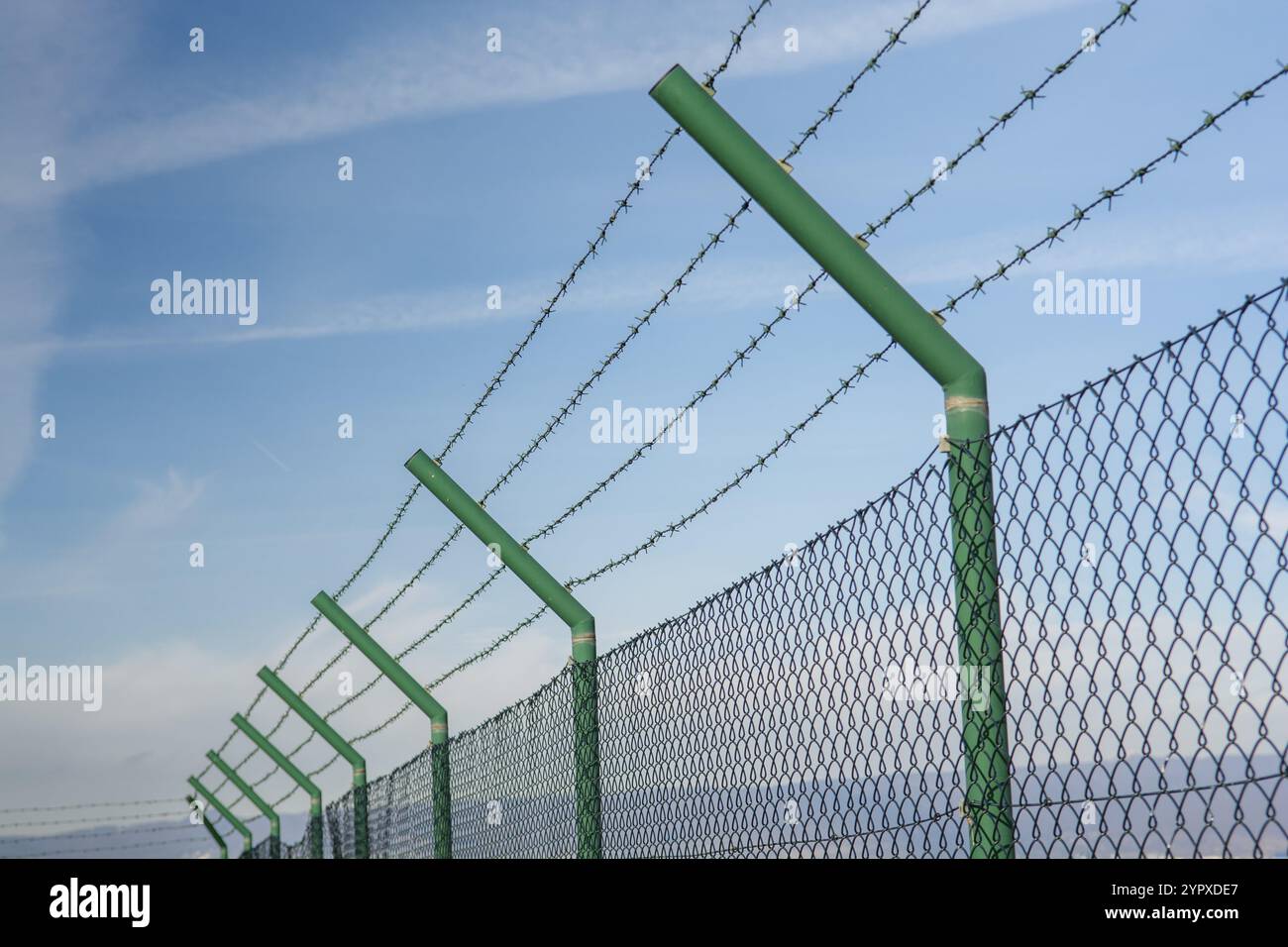 Grüner Maschendrahtzaun aus Stahl um den Flughafenbereich. Schutz von eingeschränkten Bereichen Stockfoto