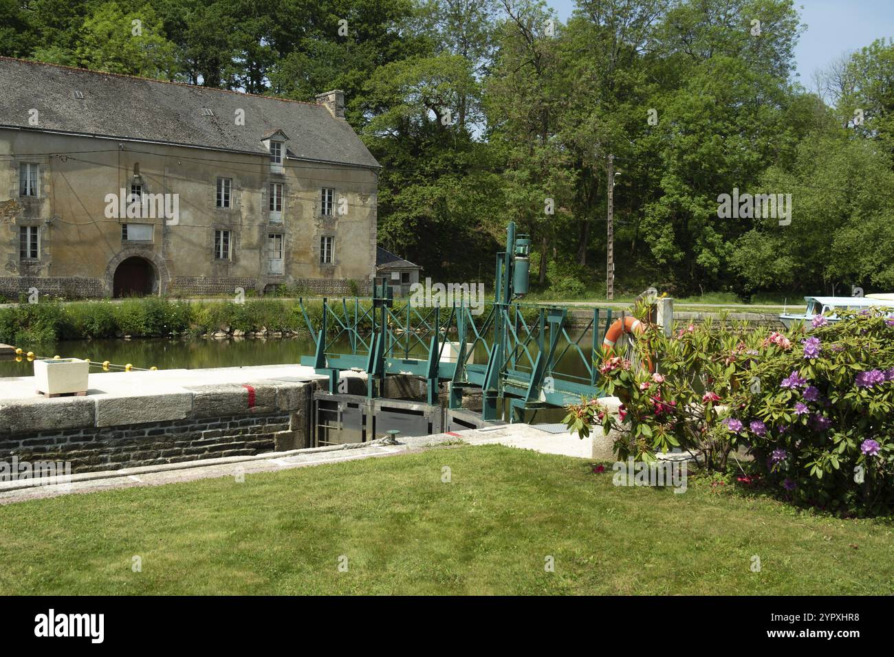 Eine historische Schleuse am Canal de nantes a Brest, Frankreich, mit einem wunderschönen Garten. Der historische Kanal wurde im 19. Jahrhundert in Europa gebaut Stockfoto