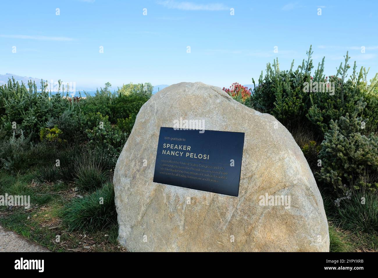 Boulder mit einer Gedenktafel in Anerkennung der Sprecherin Nancy Pelosi und ihrer Bemühungen, das Presidio in San Francisco als Nationalpark zu retten. Stockfoto