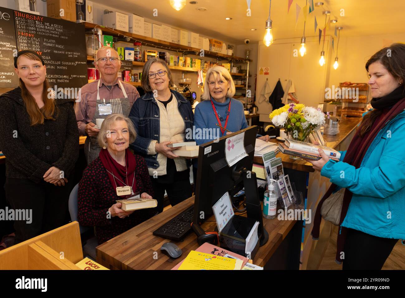 Freiwillige und ein Kreditnehmer in der Cricklewood Library im Nordwesten Londons, die von der Gemeinde geleitet wird, nachdem der Brent council die Finanzierung eingestellt hat. Stockfoto