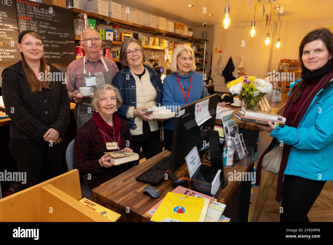 Freiwillige und ein Kreditnehmer in der Cricklewood Library im Nordwesten Londons, die von der Gemeinde geleitet wird, nachdem der Brent council die Finanzierung eingestellt hat. Stockfoto