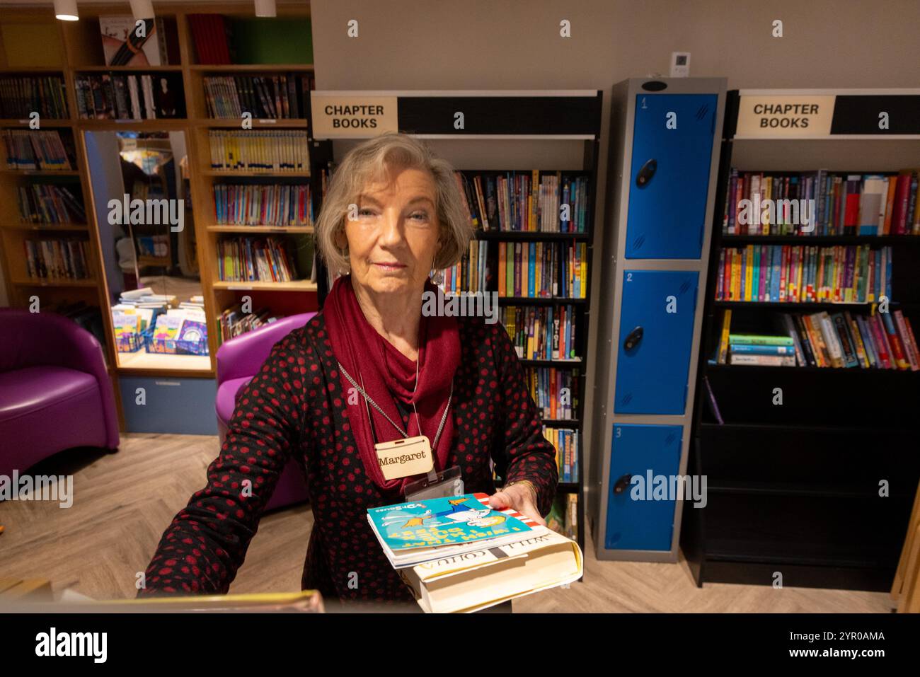 Ein Freiwilliger Bibliothekar in der Cricklewood Library im Nordwesten Londons, die von der Gemeinde geleitet wird, nachdem der Brent council die Finanzierung eingestellt hat. Die Freiwilligen Bibliotheken Stockfoto