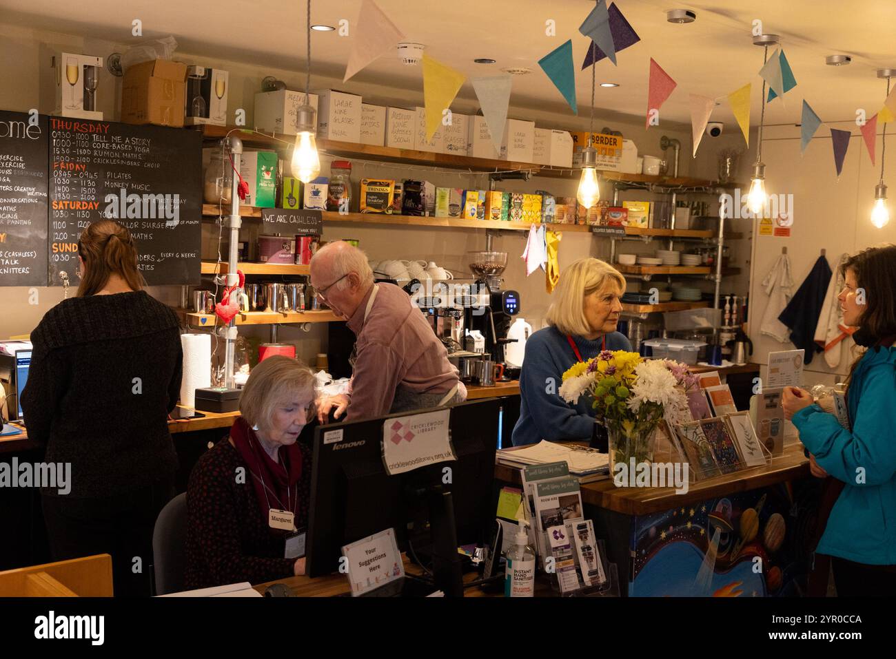 Ein Freiwilliger und ein Darlehensnehmer in der Cricklewood Library im Nordwesten Londons, die von der Gemeinde geleitet wird, nachdem der Brent council die Finanzierung eingestellt hat. Der Freiwillige li Stockfoto
