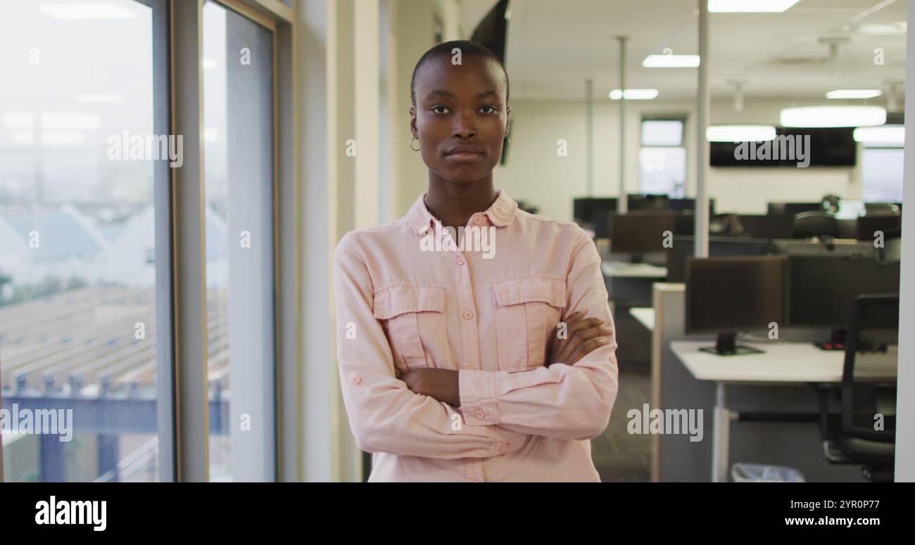 Porträt einer afroamerikanischen kreativen Geschäftsfrau mit überkreuzten Händen, die in die Kamera schauen Stockfoto