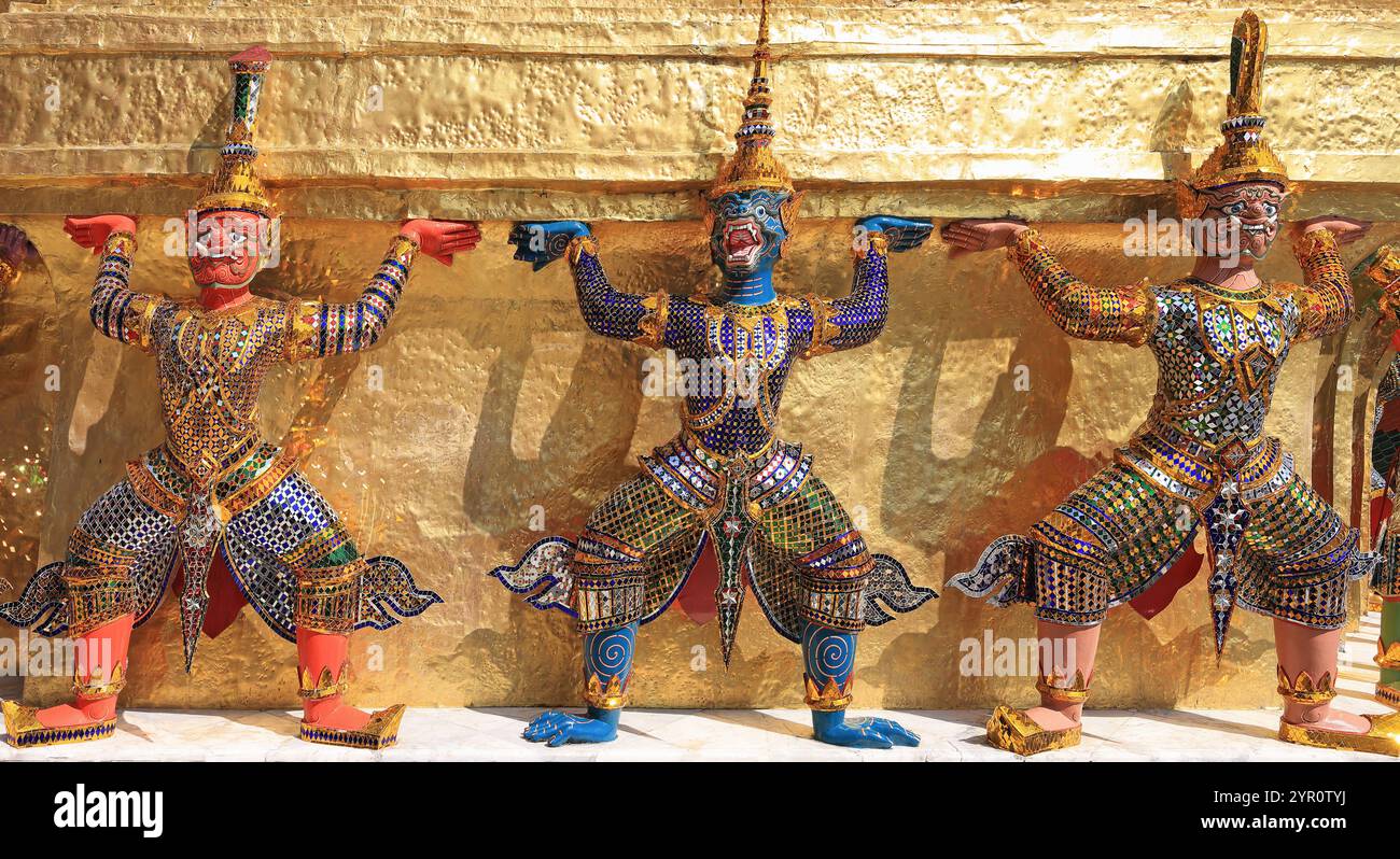 Yaksha Dämon Statuen mit dem goldenen Chedi im Tempel des Smaragd Buddha, Grand Palace, Bangkok, Thailand Stockfoto