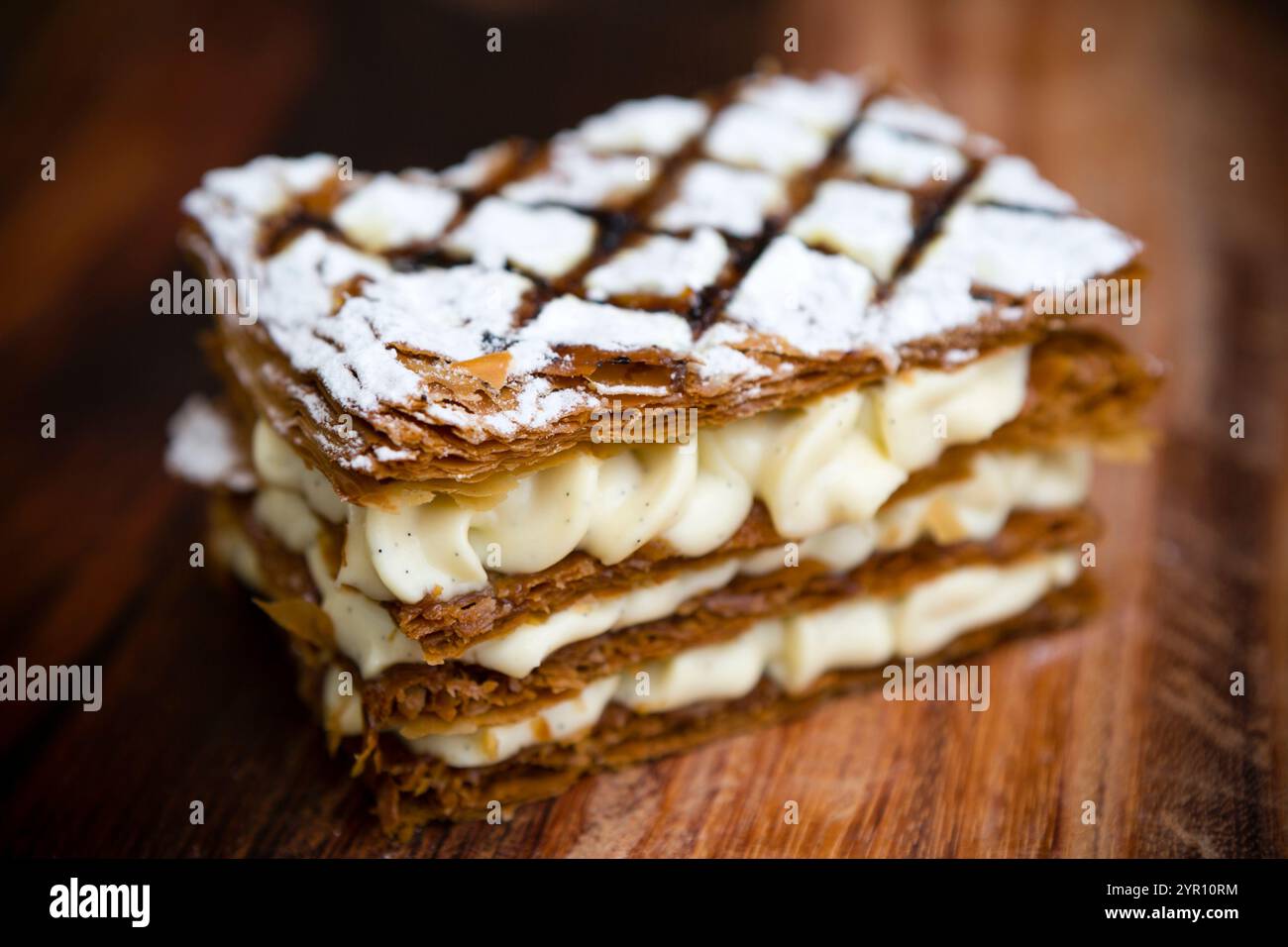 Eine französische Teigmühle, die aus mehreren Lagen Blätterteig besteht, in der Regel mit Sahne oder Pudding gefüllt und mit Zuckerguss oder Zucker belegt ist. Stockfoto