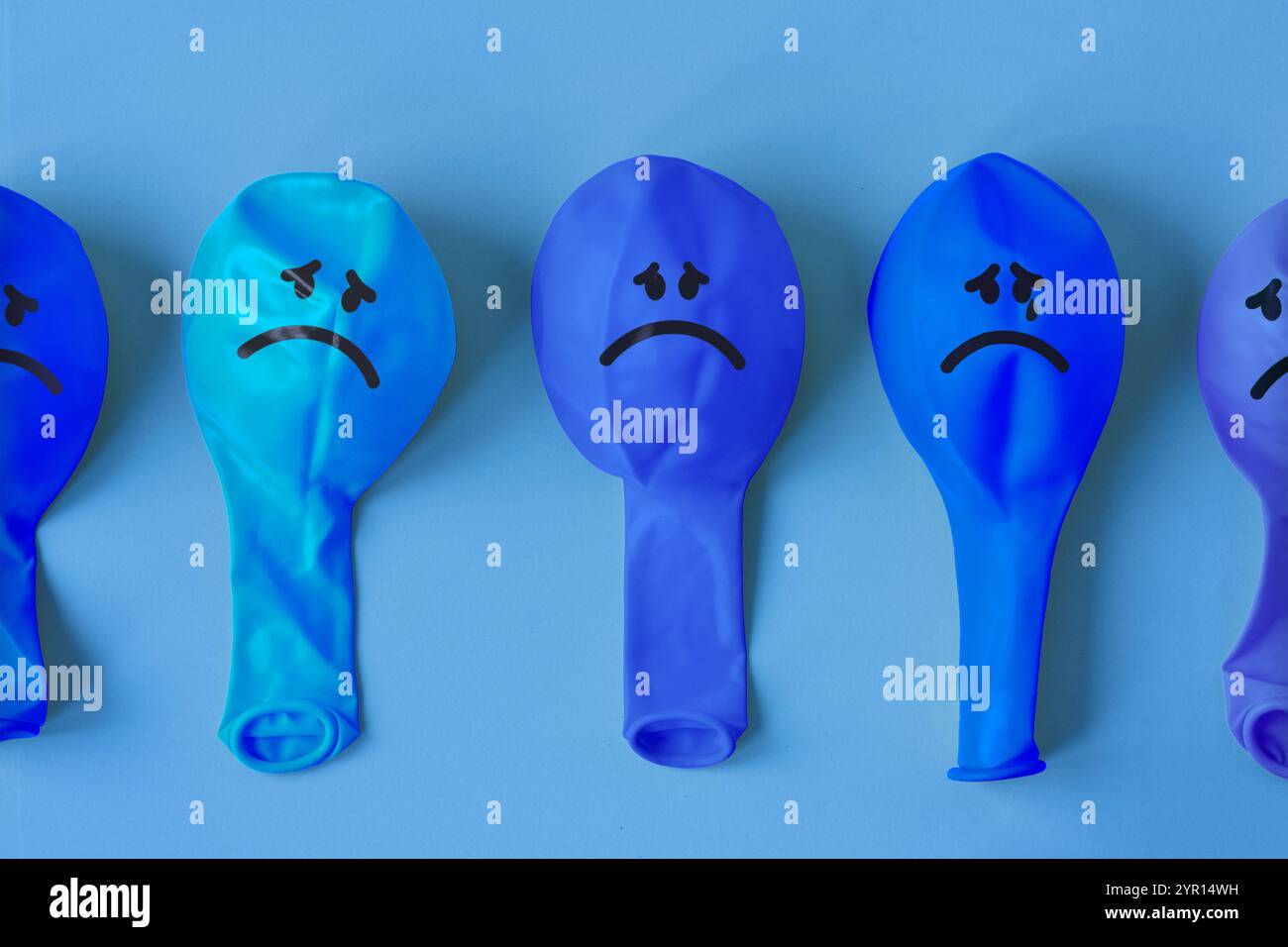 Reihe von blauen Luftballons mit traurigem Gesicht - Konzept von blauem montag, Traurigkeit und Geisteskrankheit Stockfoto