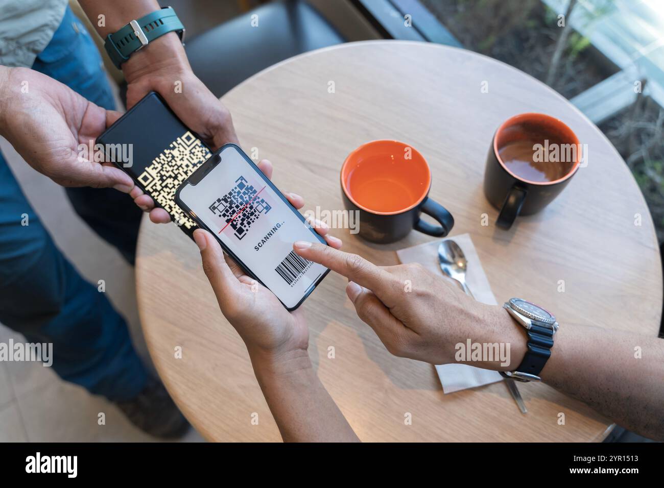 Konzentrieren Sie sich auf „hier scannen“, um Text zu bezahlen. Nahaufnahme der Hände, die QR-Code für digitale Kontakte scannen, weniger Bezahlung nach dem Einkaufen - Konzept der Technologie, Sicherheit und Stockfoto