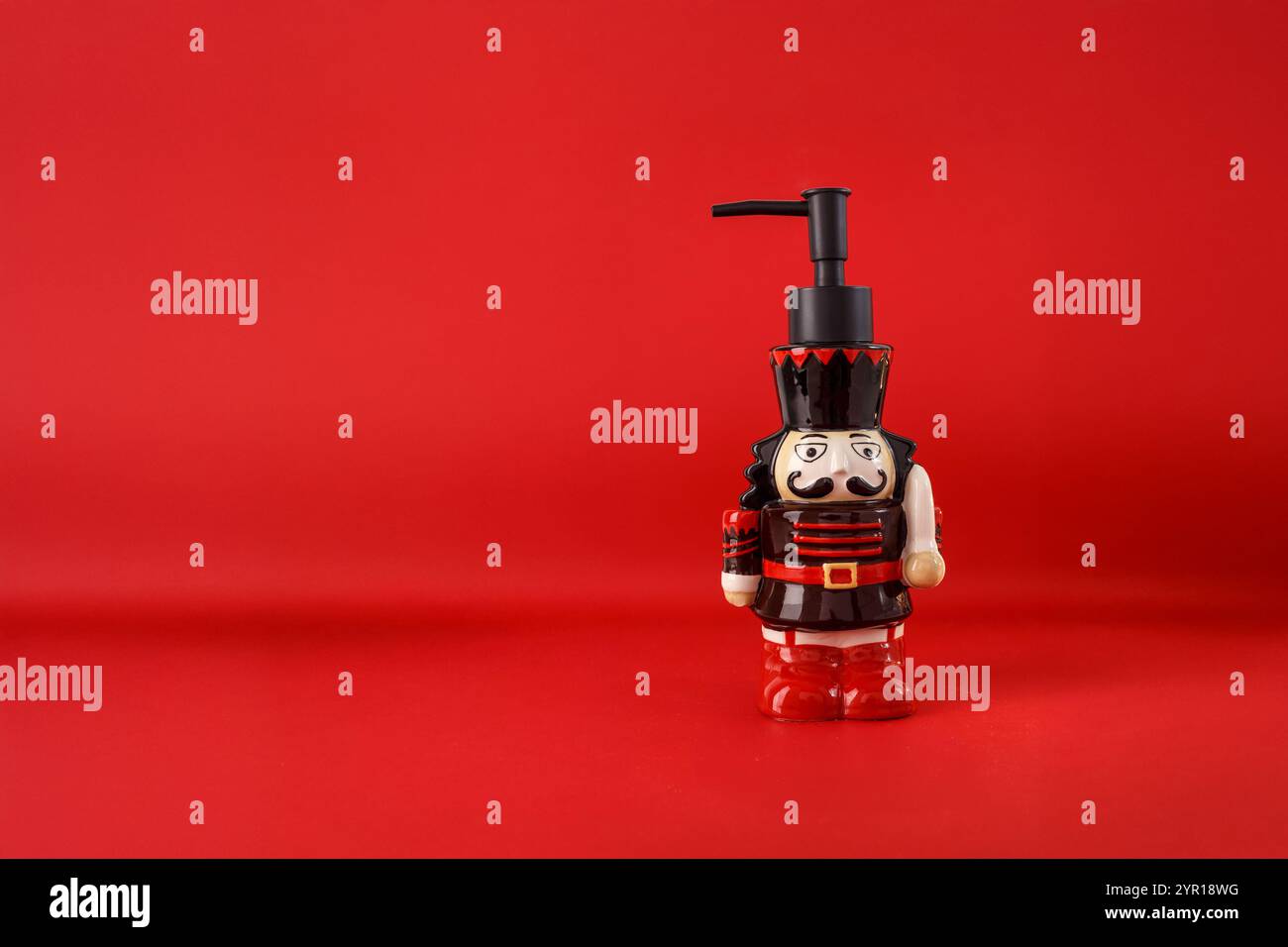Seifenspender ähnelt Spielzeugsoldat oder Nussknacker, rote schwarze Farben, detailliertes Gesicht, Schnurrbart, Uniform, festliches Weihnachtsdesign, praktisch und dekorativ Stockfoto