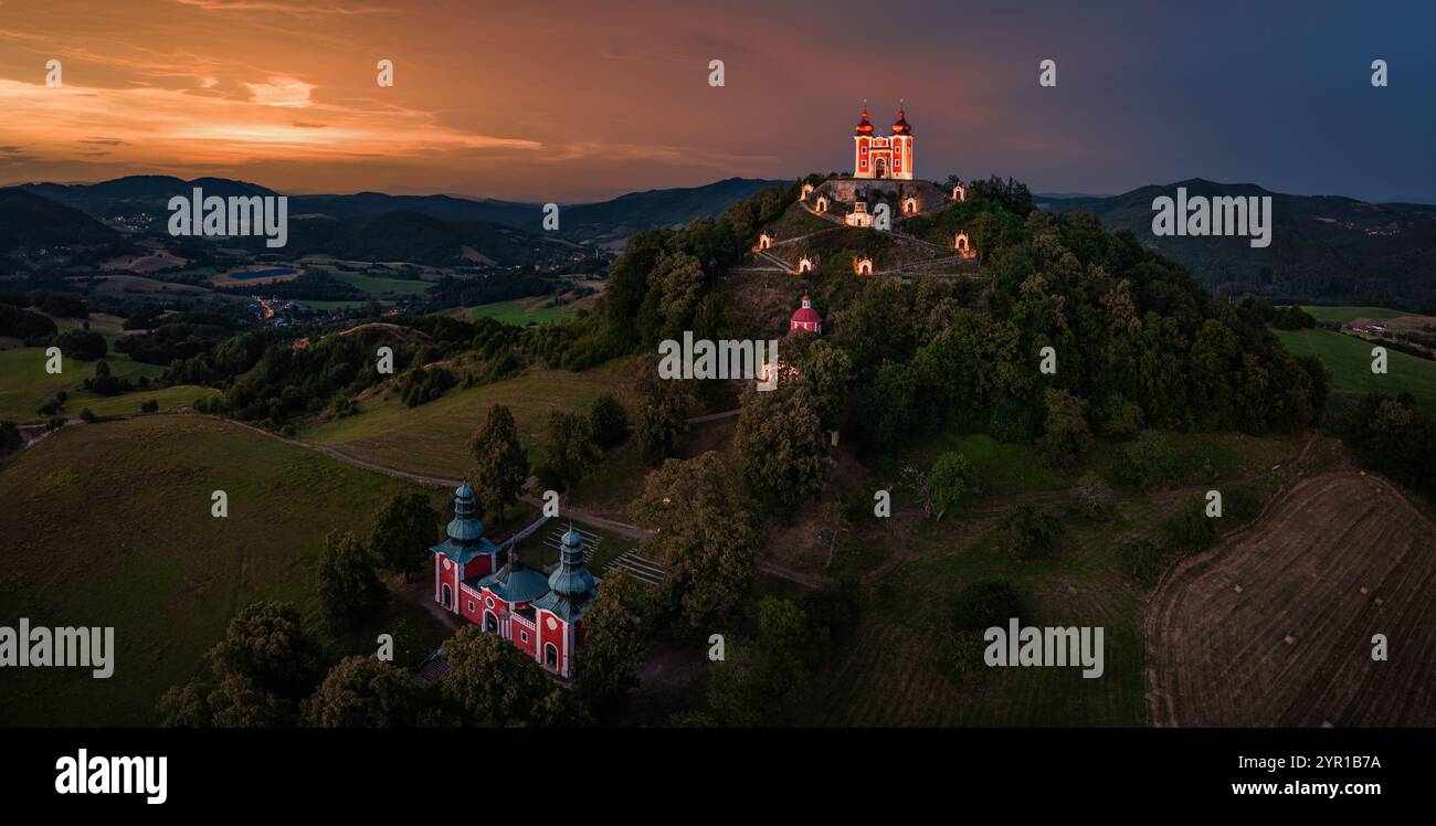 Banska Stiavnica, Slowakei - Panoramablick aus der Luft auf den wunderschönen beleuchteten barocken Kalvarienkalvaria in der Slowakei bei Dämmerung an einem Sommernachmittag mit Dramati Stockfoto