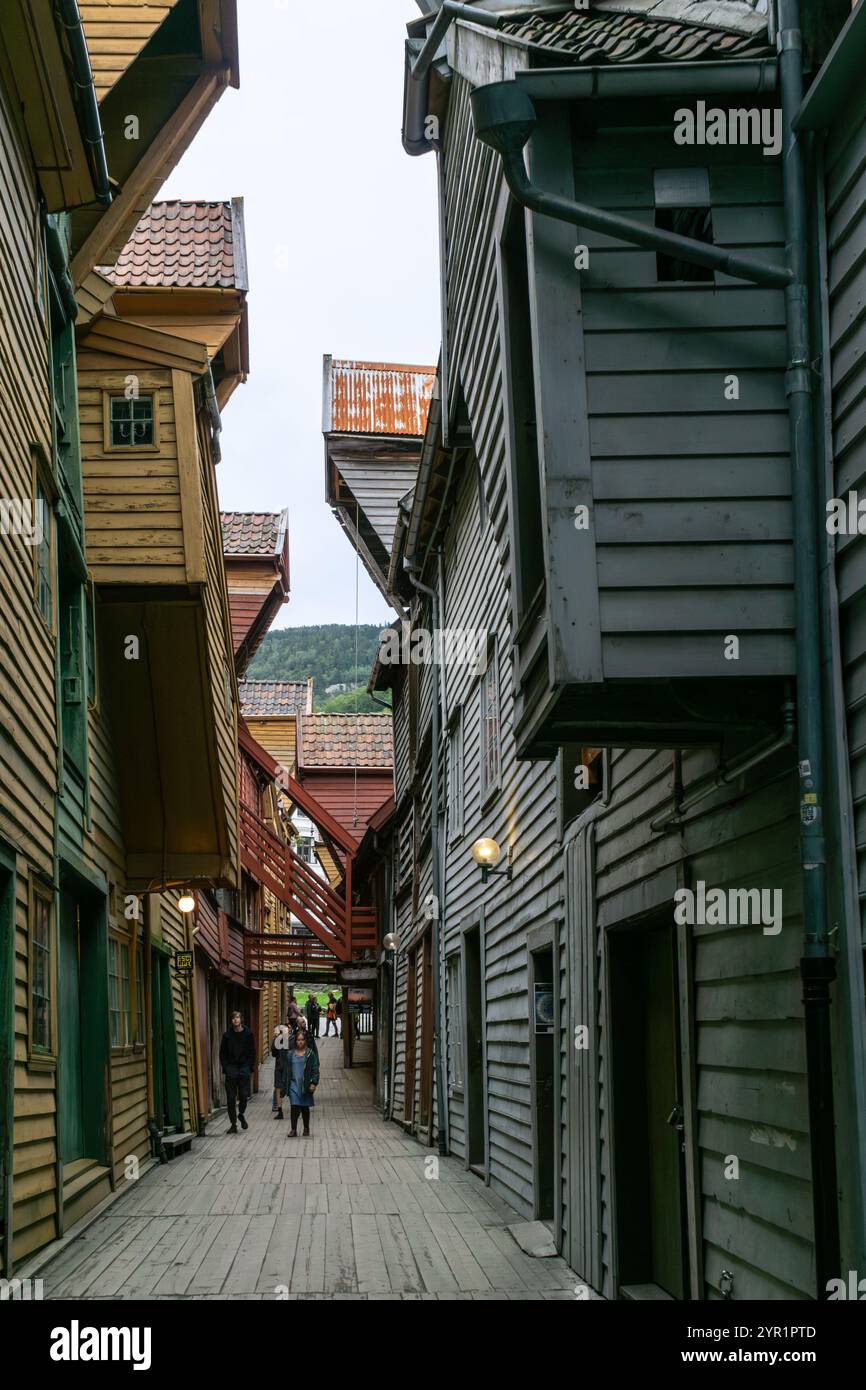Bergen, Norwegen - 8. August 2022: Menschen schlendern durch die engen Gassen des berühmten und historischen Stadtviertels Brygge Stockfoto