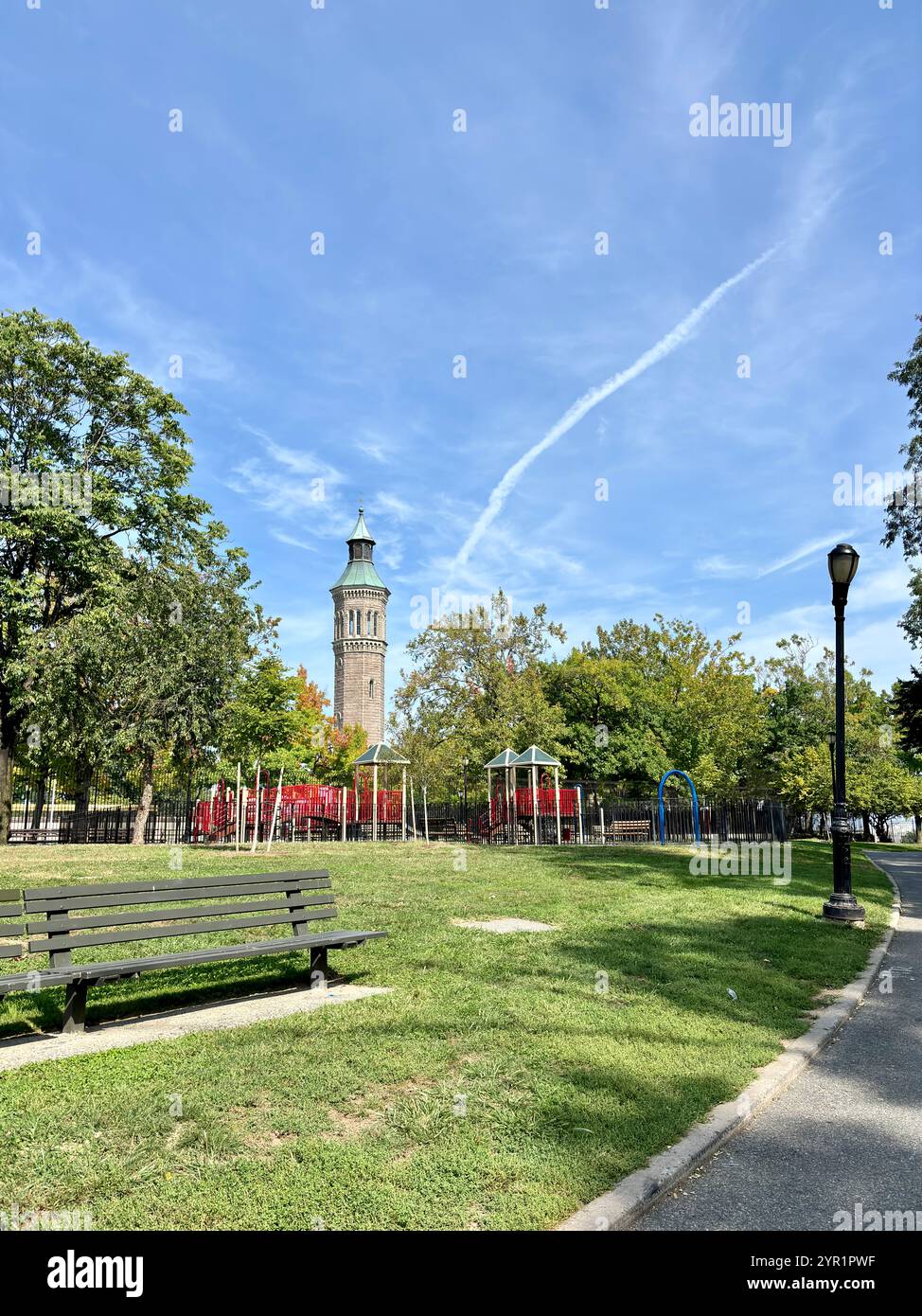 Parkbank und Spielplatz vor dem Highbridge Water Tower in Harlem Stockfoto