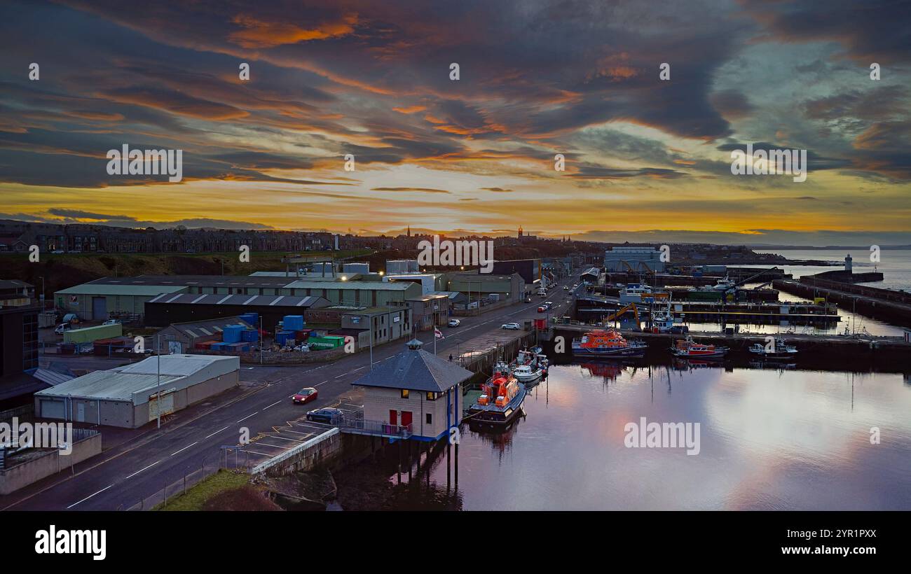 Buckie Harbour Moray Coast Schottland Winter farbenfroher Sonnenuntergang mit verankerten Rettungsbooten Stockfoto