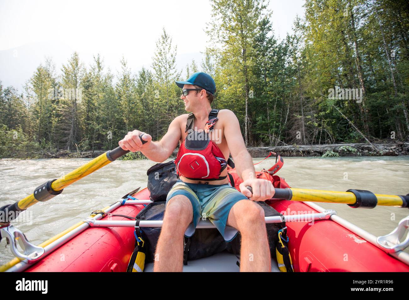 Nahaufnahme eines Mannes, der Rettungsweste trägt und Flussfloß rudert Stockfoto