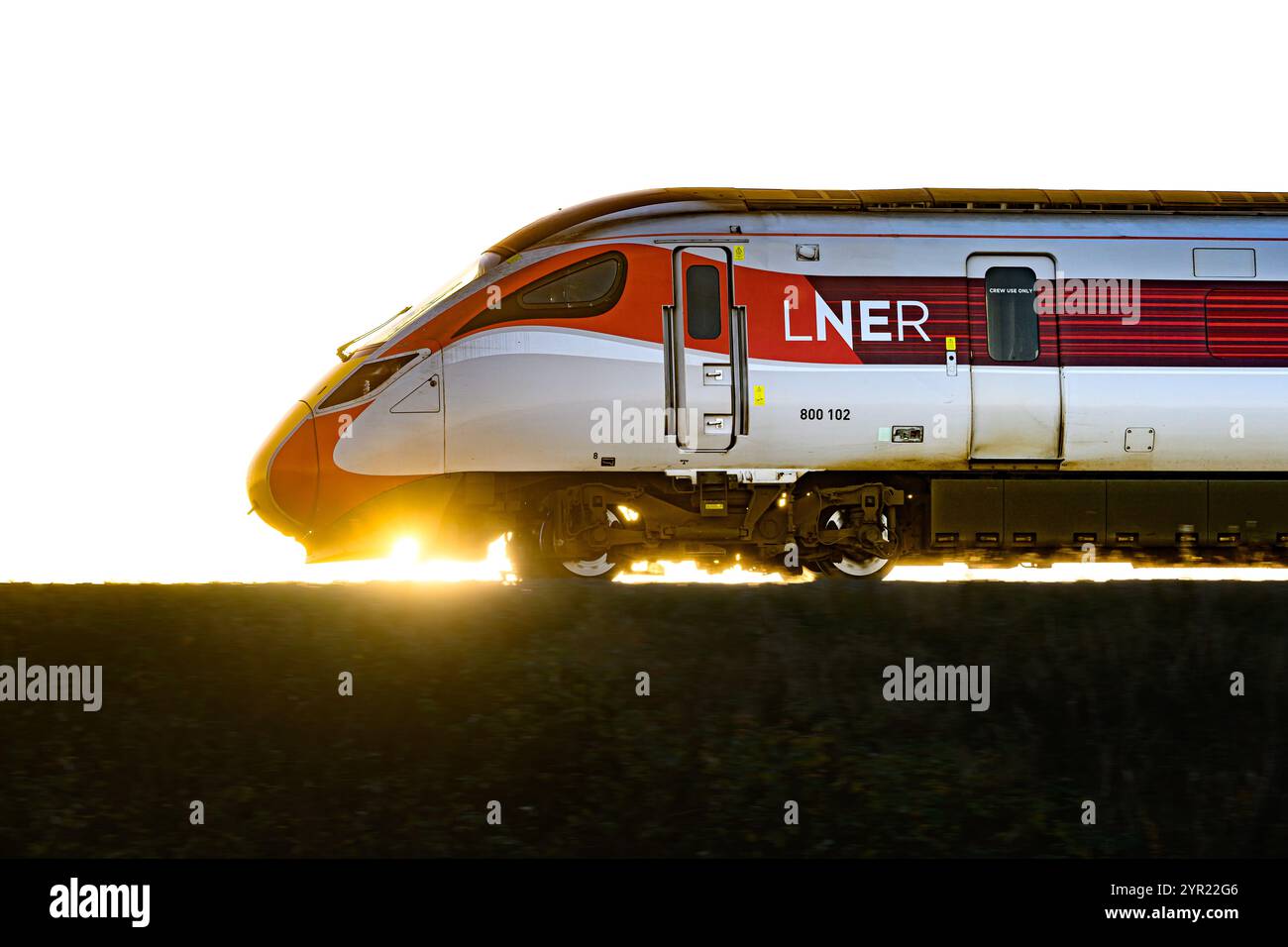 Ein LNER Azuma Train (800102), der von Einem Sonnenuntergang beleuchtet wird, während er zwischen Dalmeny und Edinburgh Gateway Stations in Schottland (Großbritannien) fährt Stockfoto