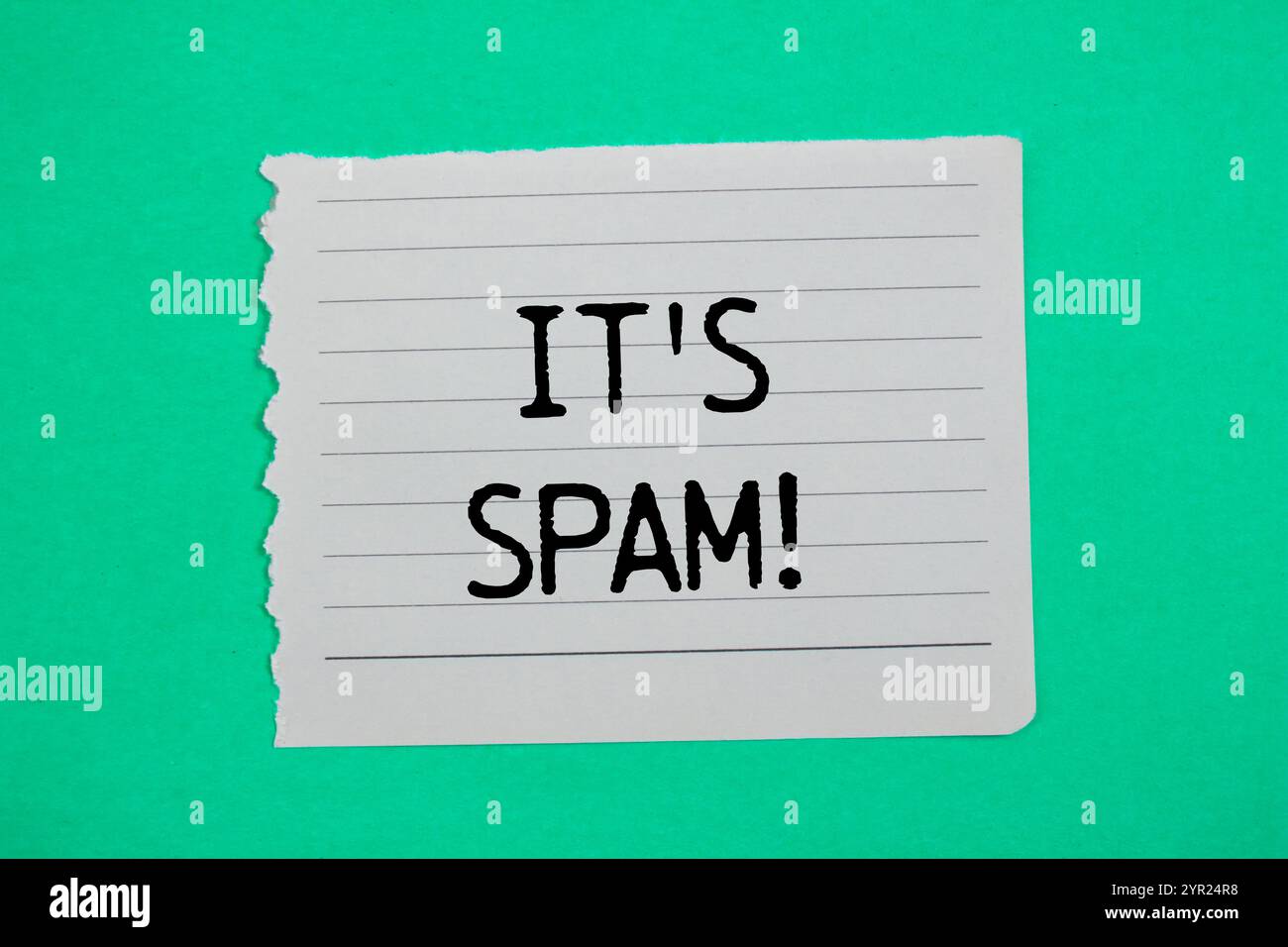 Es ist eine Spam-Nachricht, geschrieben auf zerrissenem Papier mit grünem Hintergrund. Konzeptionell ist das Spam-Symbol. Kopierbereich. Stockfoto