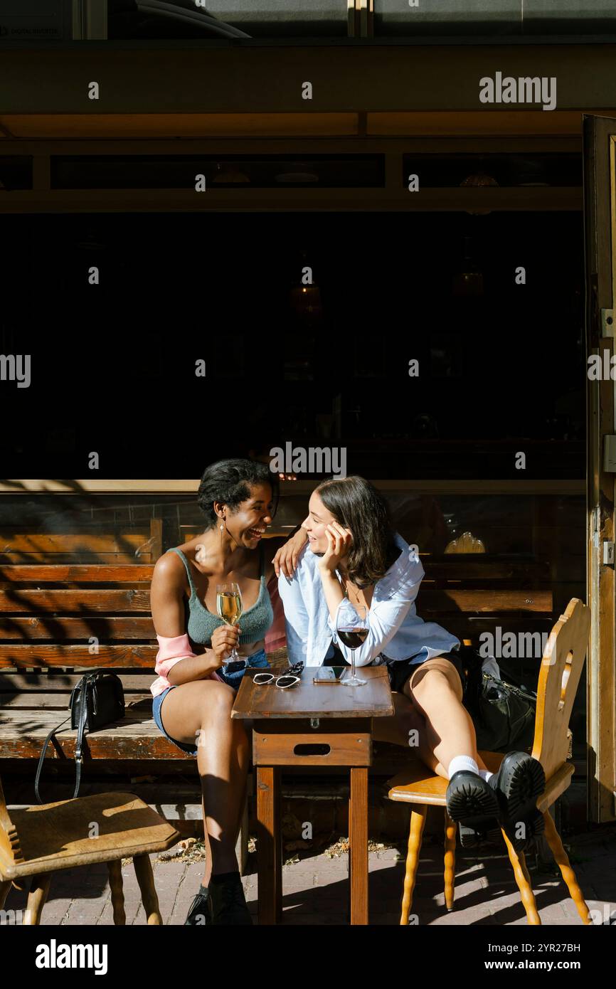 Weibliche Freunde, die miteinander reden, während sie im Restaurant sitzen Stockfoto