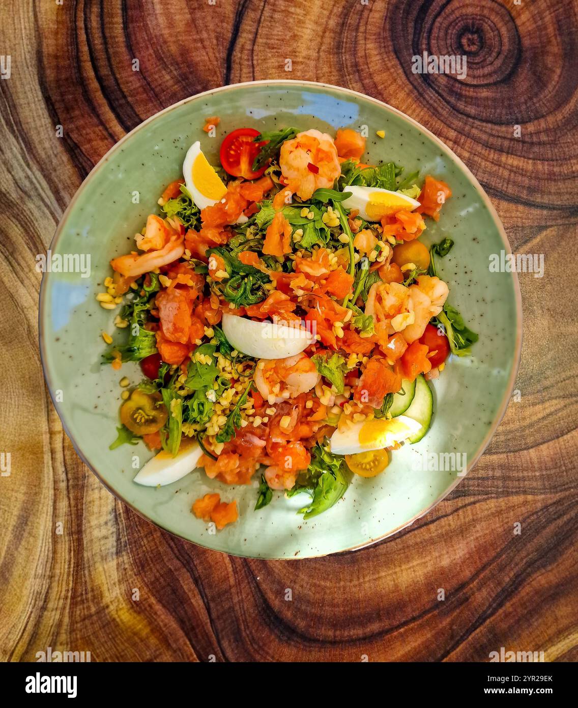 Dekorativer Lunch-Teller mit Salat mit Zutaten wie Flusskrebs und verschiedenen Bio-Gemüsesorten wie Eichenblattsalat, Raketenblättern und Tomaten Stockfoto