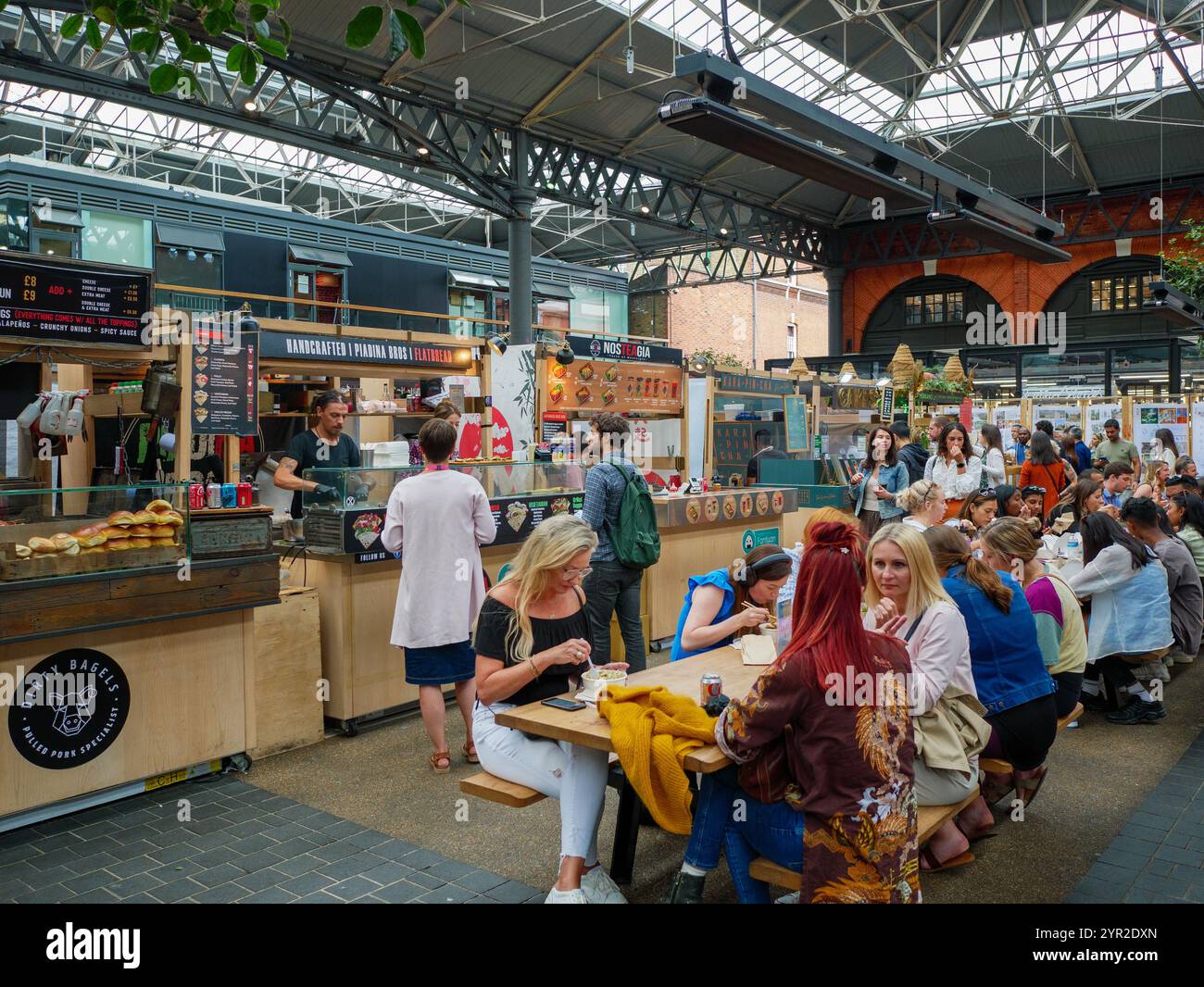 Leute essen an den Imbissständen in Spitalfields Market, London, Großbritannien Stockfoto