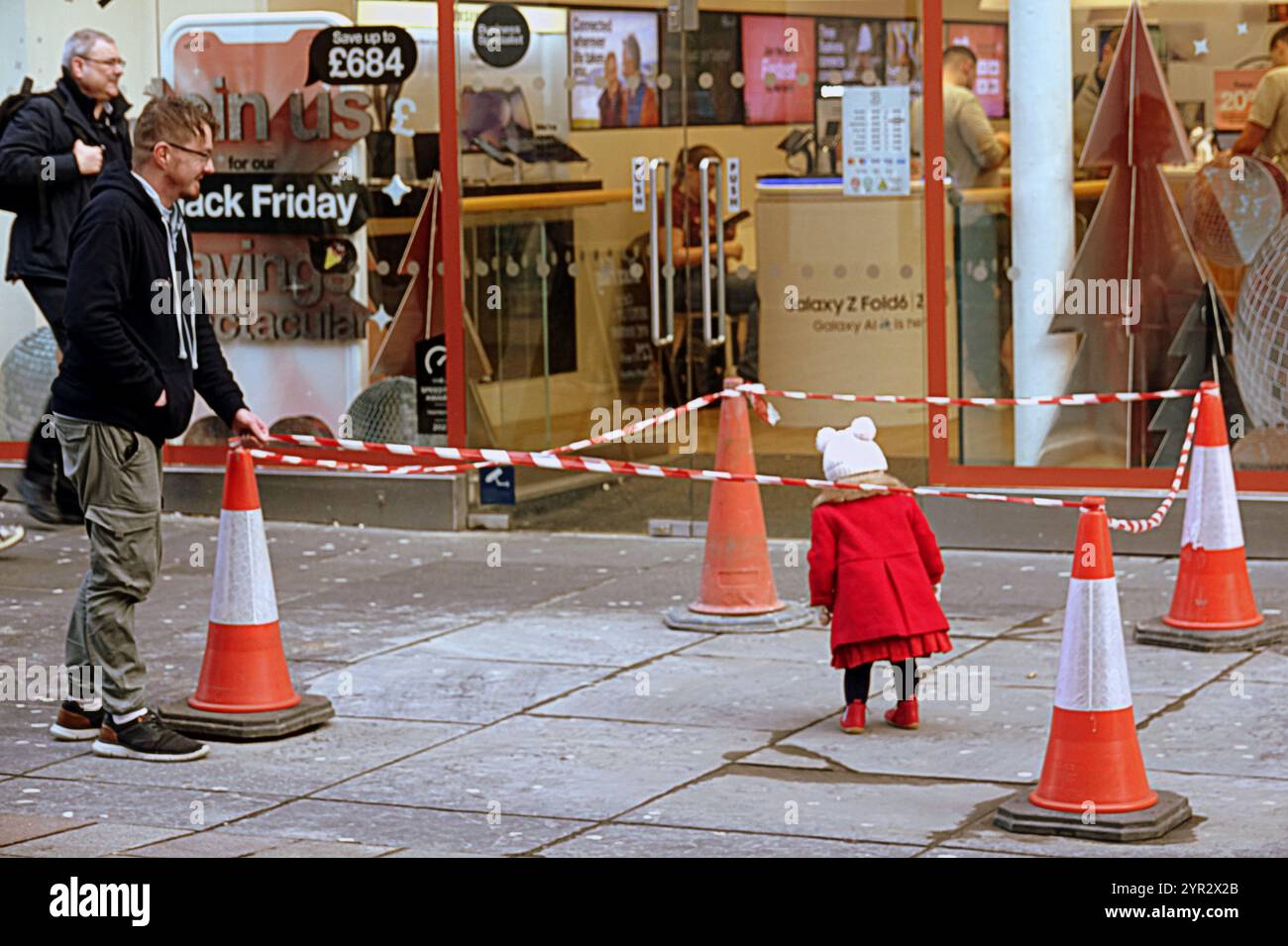 Glasgow, Schottland, Großbritannien. Dezember 2024. Wetter in Großbritannien: Auf der buchanan Street wurde ein kleines Zelt wegen eines beschädigten Pflastersteins, der als Spielkugel diente, in einem abgetrennten Bereich untergebracht. Das langweilige Wetter und ein nasser Tag sahen einen dystopischen Anblick im Stadtzentrum, als die Stimmung der Einheimischen dem Wetter entsprach, mit fortwährenden Streitigkeiten über Mülltonnen und Obdachlosen, die die die Szene im Stadtzentrum betteln. Credit Gerard Ferry/Alamy Live News Stockfoto