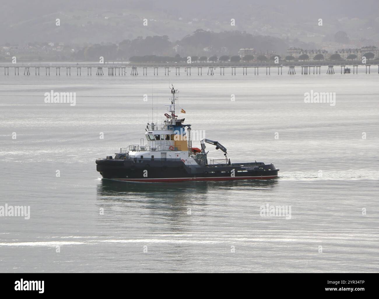 Spanisch Tug Trheintaycuatro in der Bucht von Santander Cantabria Spanien fährt an einem ruhigen Herbsttag auf ein eintreffendes Schiff Stockfoto