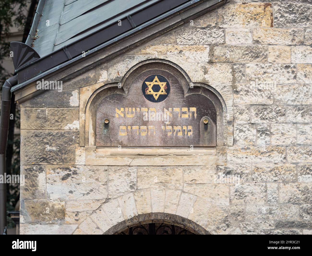 Symbol des Sterns Davids auf der Fassade des Zeremonialsaals in Prag. Nahaufnahme des religiösen Zeichens mit hebräischem Text darunter. Stockfoto