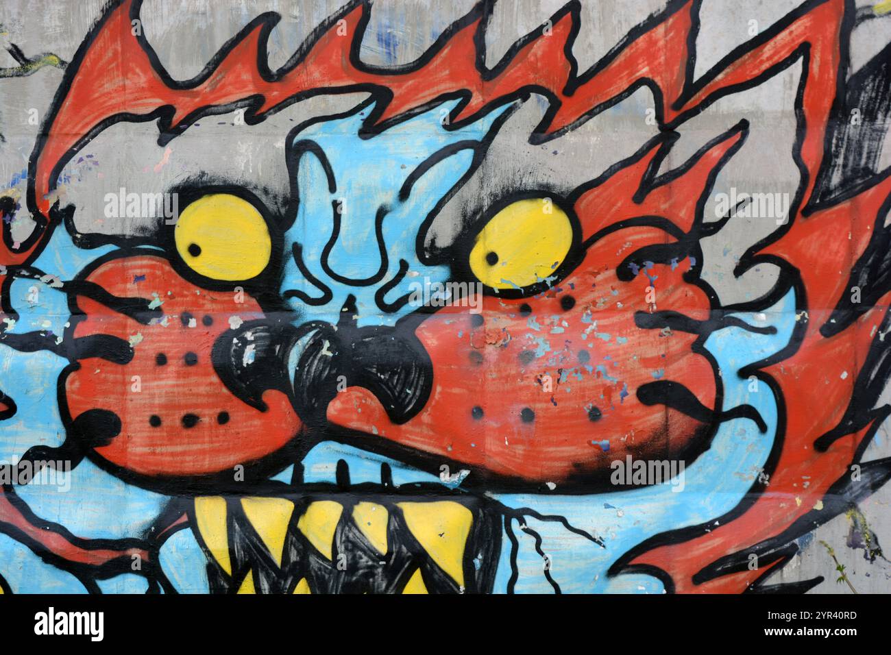Wunderschöne, lebendige Zeichnungen und Tierbilder auf einer bräunlich-grauen Betonwand. Graffiti, ein großer Kopf, die Mündung eines Tigers mit Blau, Grau. Stockfoto