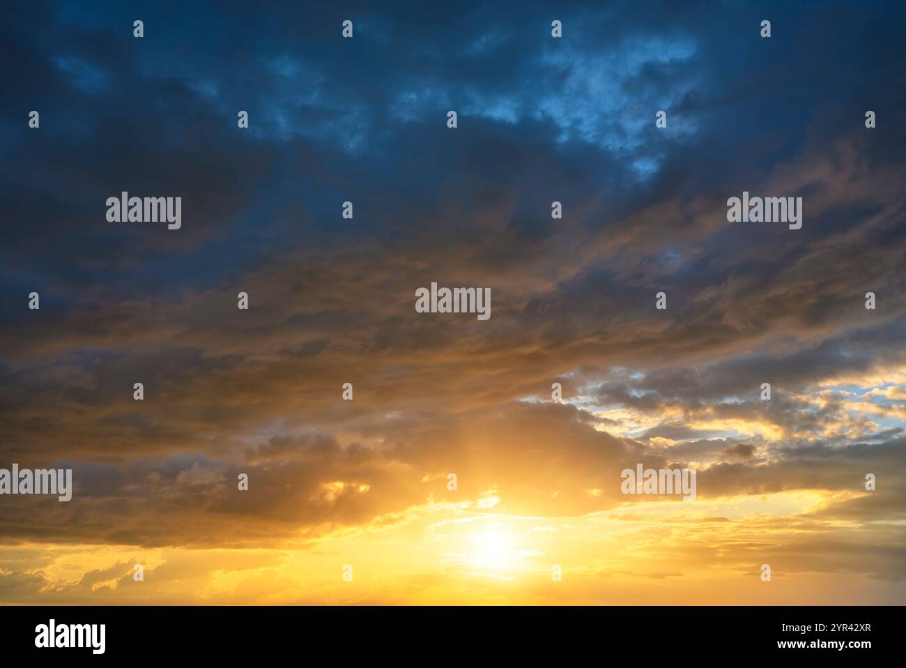 Echter Himmel Textur Hintergrund mit heller Sonne bei Sonnenuntergang. Dramatische rote, orange und violette Wolken. Hochauflösende Fotografie, perfekt für den Austausch des Himmels Stockfoto