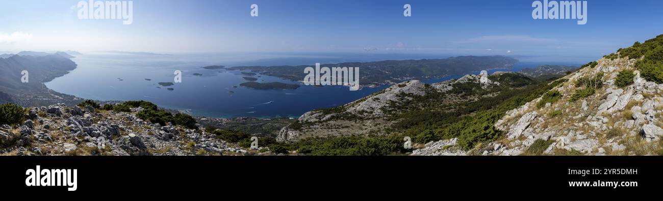 Panoramablick über eine Küste mit Inseln (Korcula) und Bergen im Hintergrund unter klarem Himmel, Korcula, Kroatien, Europa Stockfoto