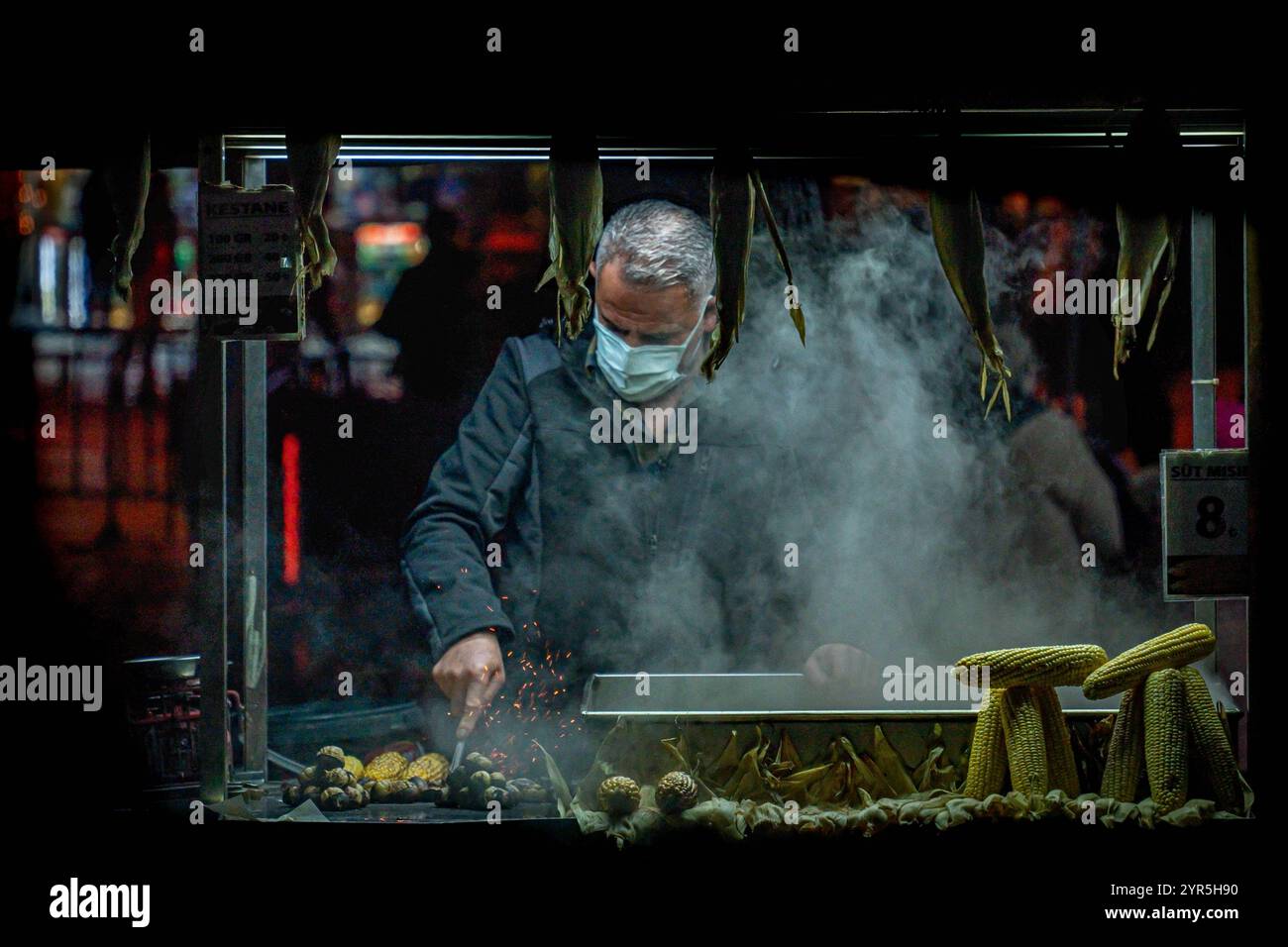 ISTANBUL, 9. JANUAR 2022: Ein Maisverkäufer am Abend im Zentrum von Istanbul, Türkei. Istanbul ist die größte Stadt der Türkei Stockfoto