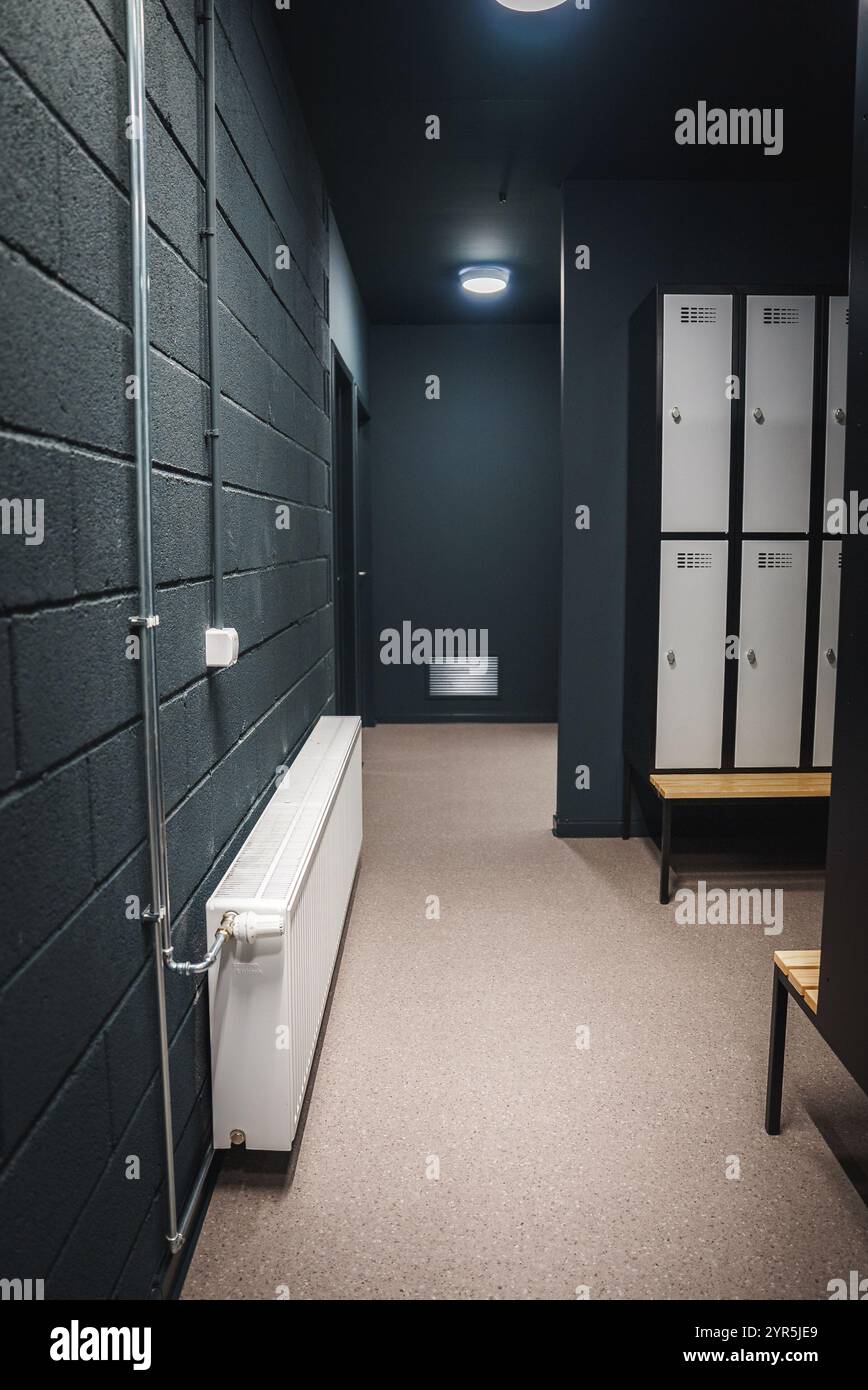 Moderner Schließfachraum mit einer Reihe von Schließfächern und einer Bank in der Sporteinrichtung Stockfoto