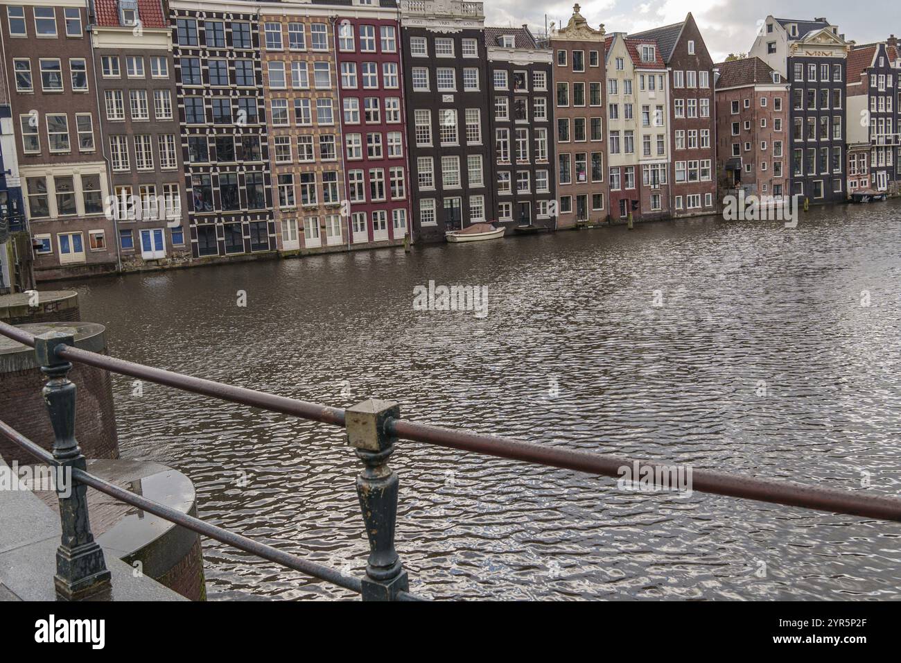 Eine Reihe von Häusern am Ufer mit einem Geländer im Vordergrund, Amsterdam, Niederlande Stockfoto