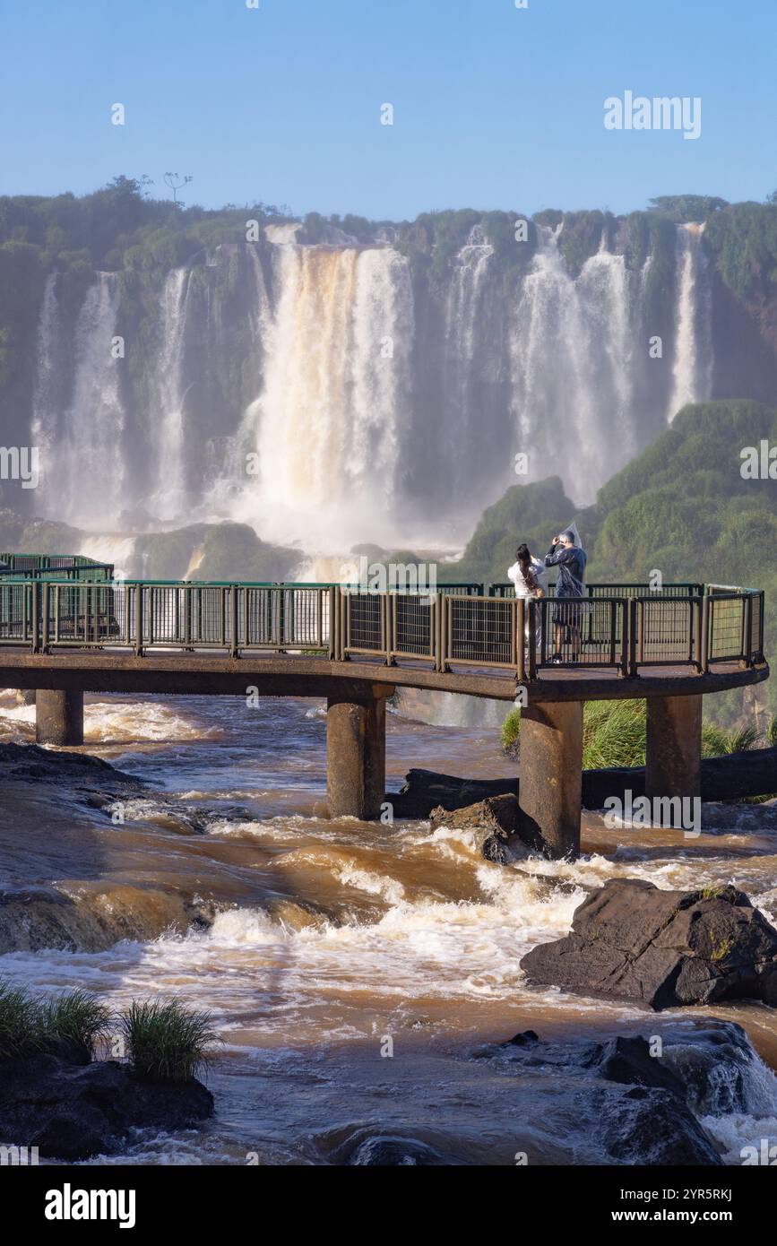 Brasilien Touristen; Ein Touristenpaar am Wasserfall Iguazu Falls, auf einer ansonsten verlassenen brasilianischen Seite; Iguassu Falls, Brasilien Südamerika reisen. Stockfoto