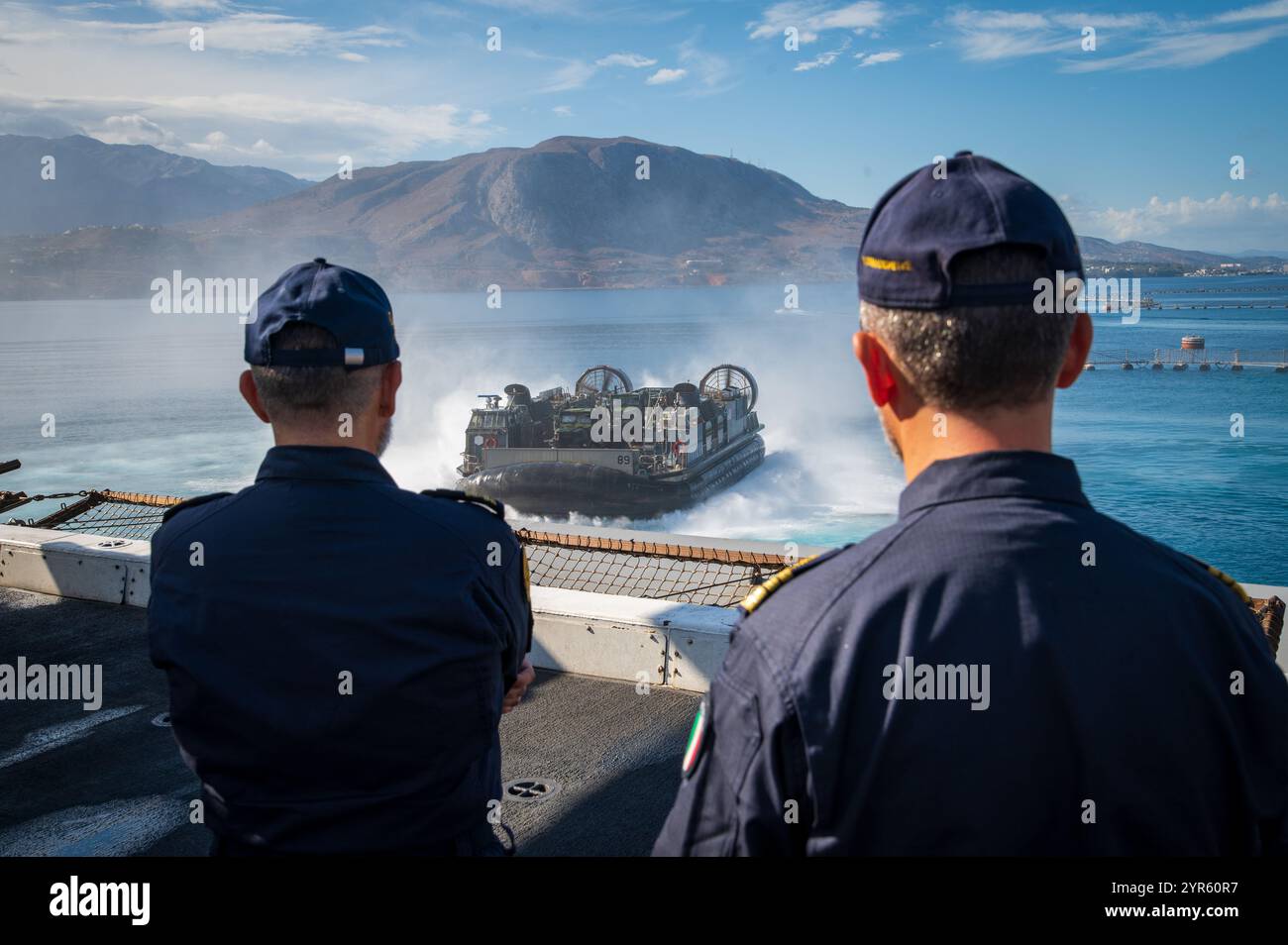 241115-N-UF626-1056 SOUDA BAY, GRIECHENLAND (15. Nov. 2024) – italienische Marine-Hinterachse Andrea Petroni, links, Kommandeur der italienischen 2. Marinedivision und Commander der italienischen Marine. Giuseppe Lucafò, Befehlshaber der italienischen Fregatte Luigi Rizzo (F 595) beobachtet ein Landungsboot der US Navy, das der Beach Assault Unit 21 zugewiesen ist, vom Flugdeck des Amphibien-Transportdocks der San Antonio-Klasse USS New York (LPD 21) während einer Schiffstour am 15. November 2024. New York führt Operationen im Gebiet der U.S. Naval Forces Europe and Africa (NAVEUR-NAVAF) im Rahmen der Wasp Amphibious Read durch Stockfoto