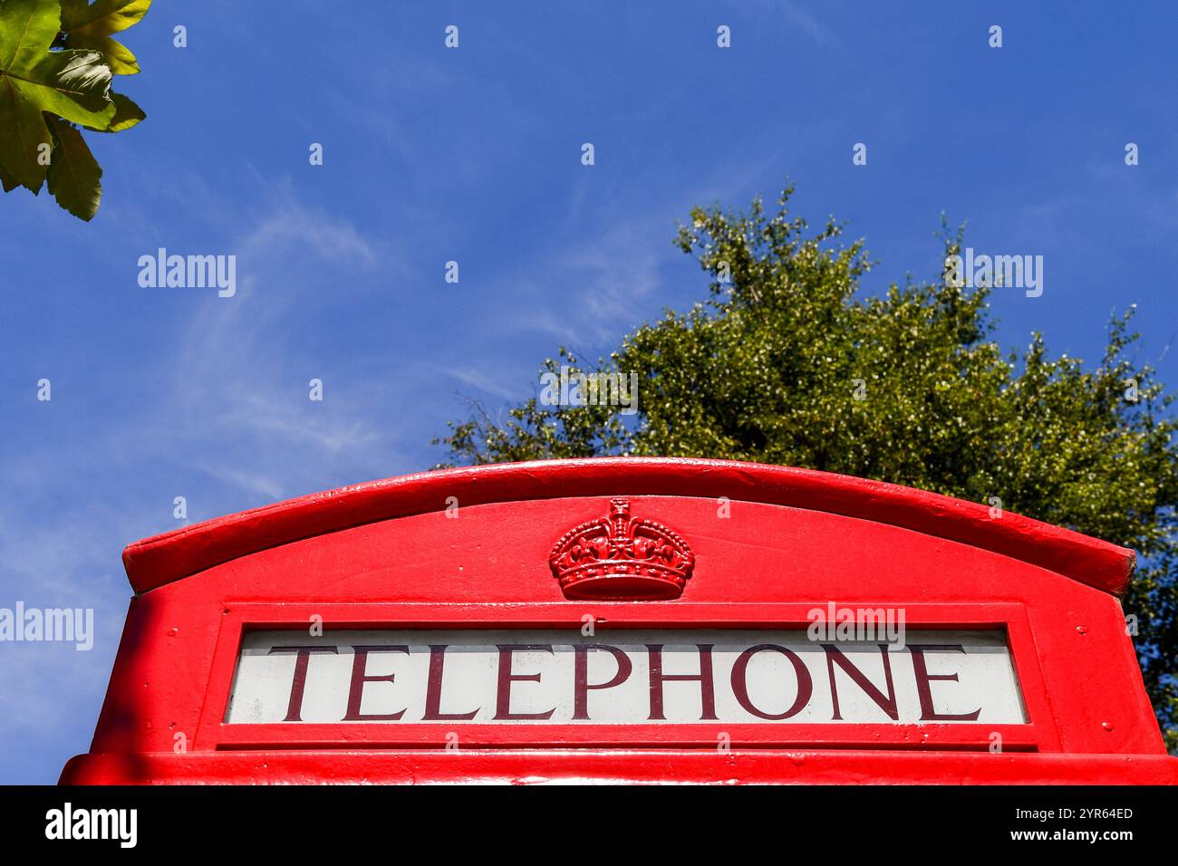 Hochteil einer roten Telefonbox vor blauem Himmel Stockfoto